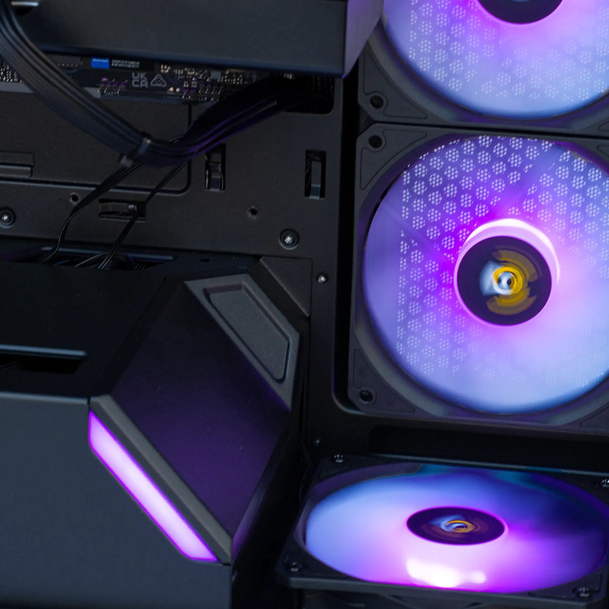 Paars verlichte computerfans met kabels in een pc-behuizing.