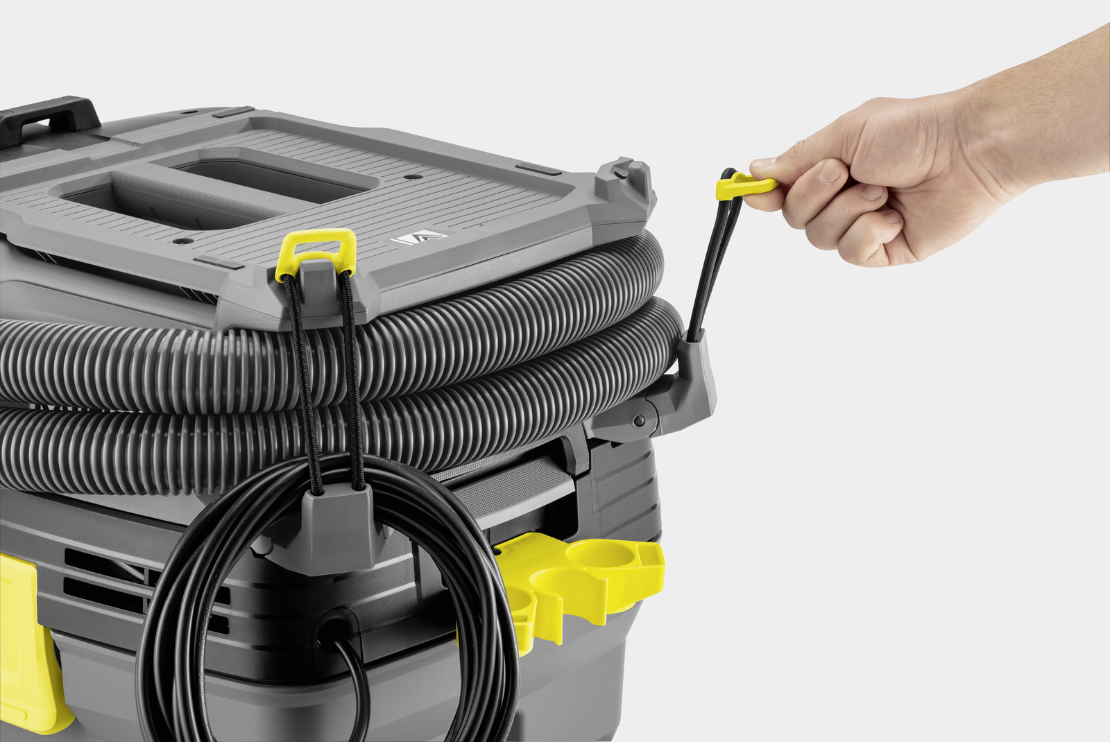 Gray Kärcher vacuum with yellow handle, black hose and cord.