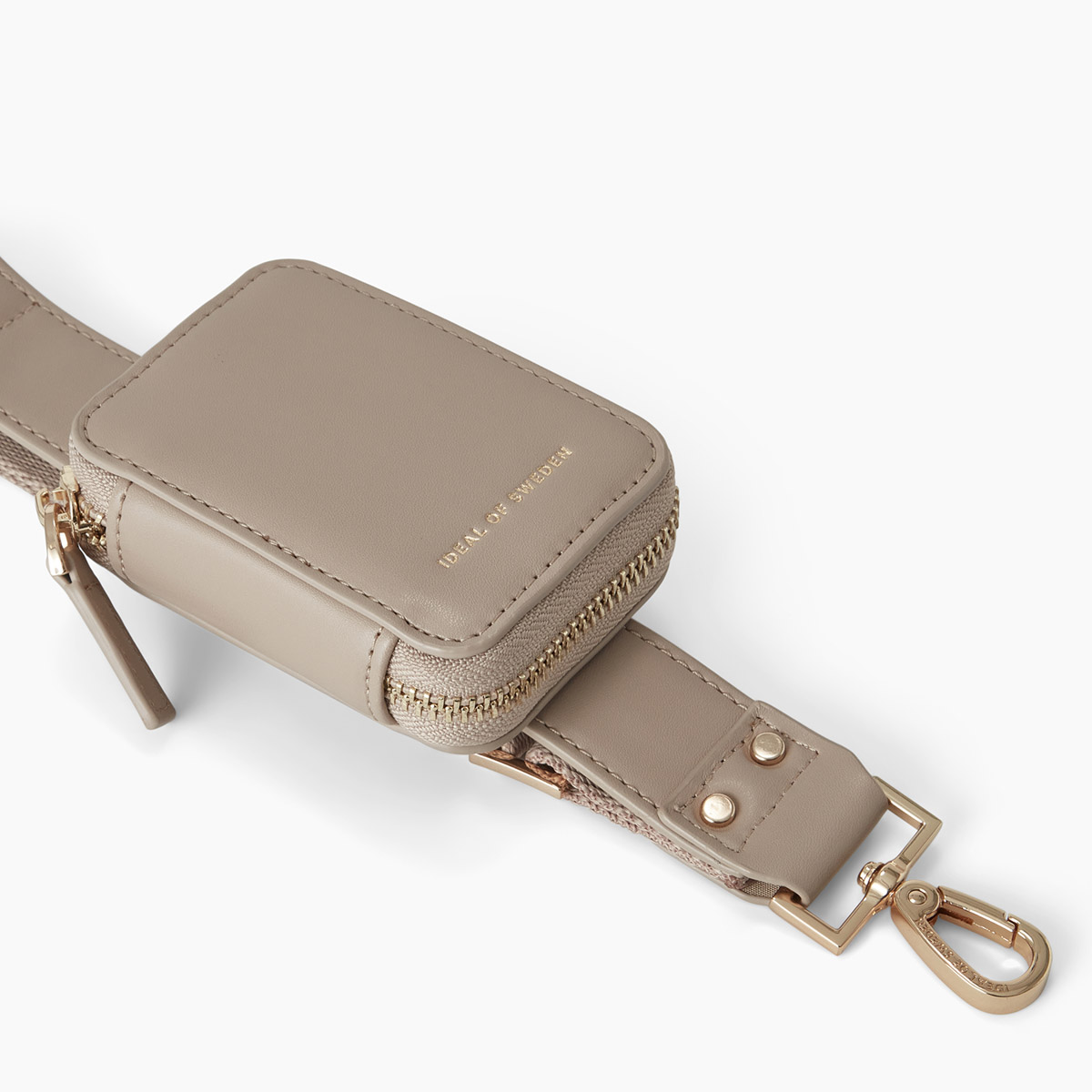 Eine beige Tasche mit Reißverschluss und goldenen Beschlägen auf einem weißen Hintergrund.