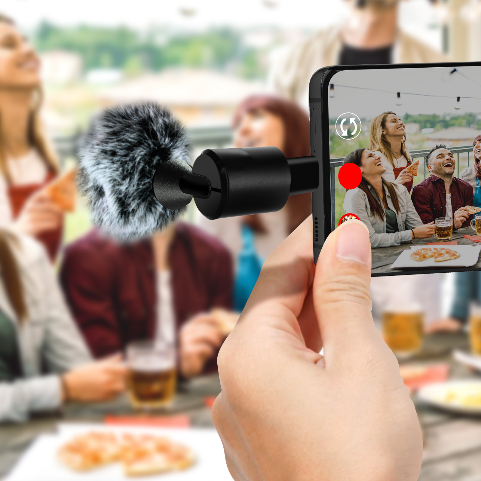 Uno smartphone riprende un gruppo di amici che mangiano pizza e bevono birra.