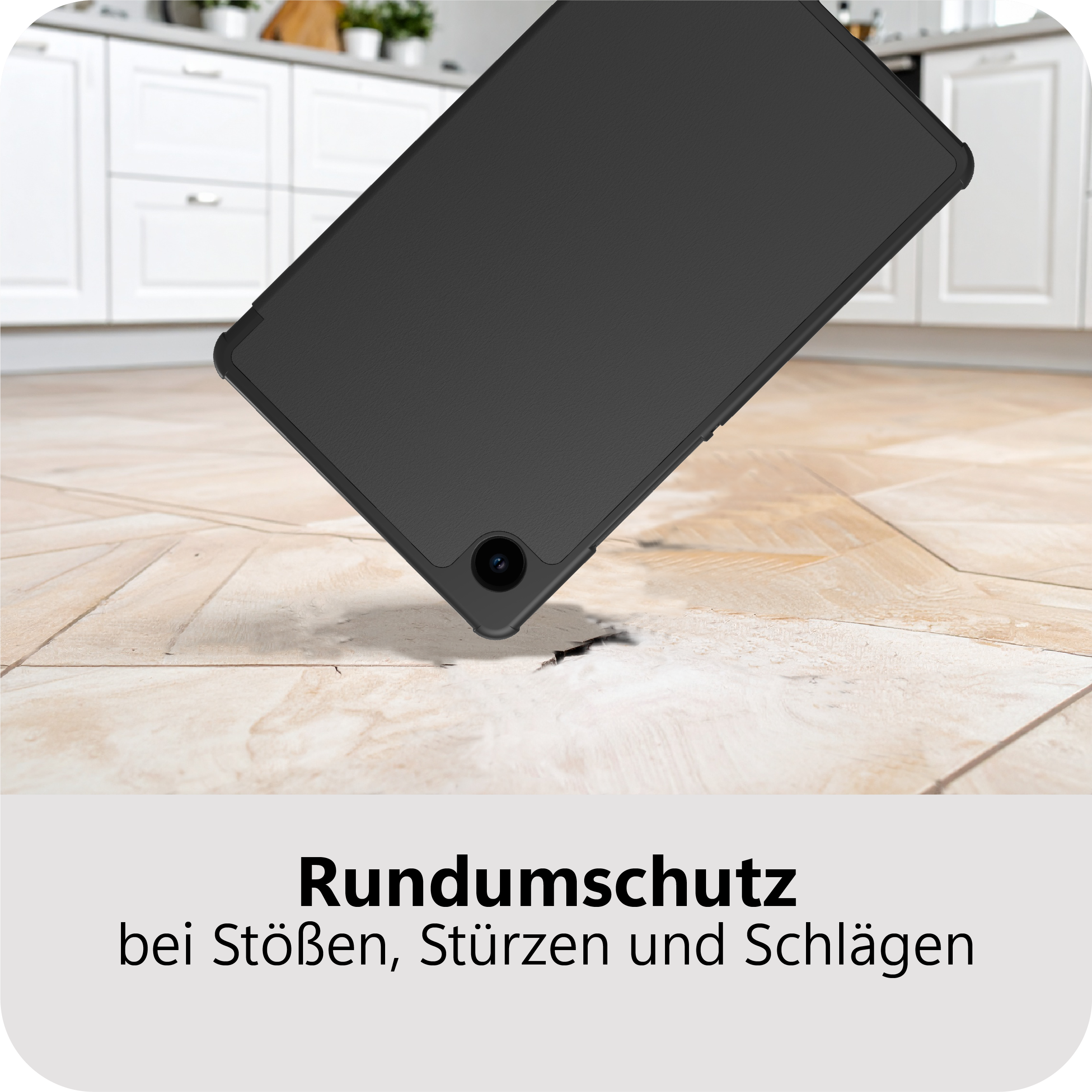 Schwarzes Tablet fällt auf Holzboden, vor weißen Küchenschränken.