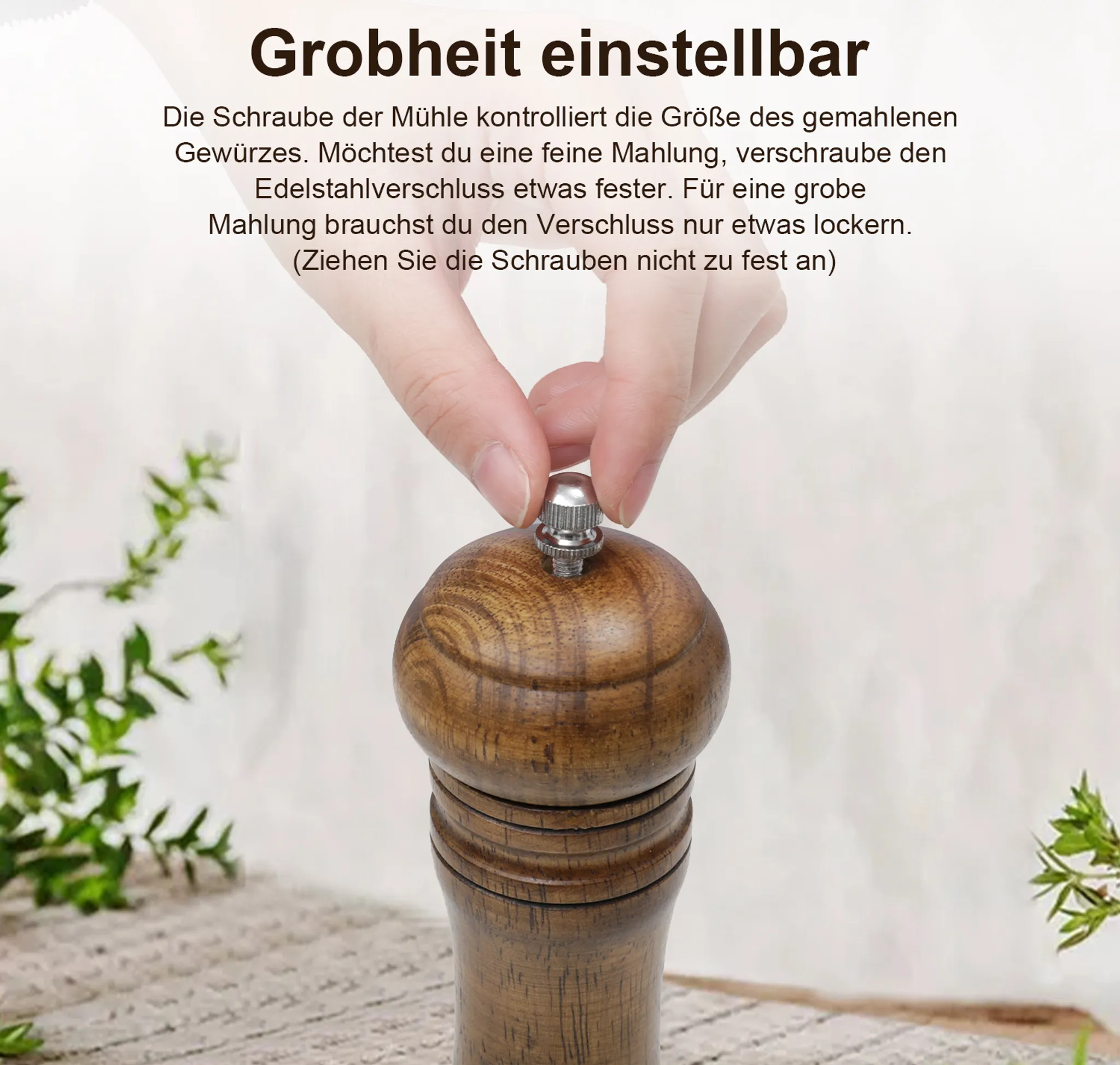 Eine Hand verstellt die Grobheit einer Holzgewürzmühle mit einer Schraube.