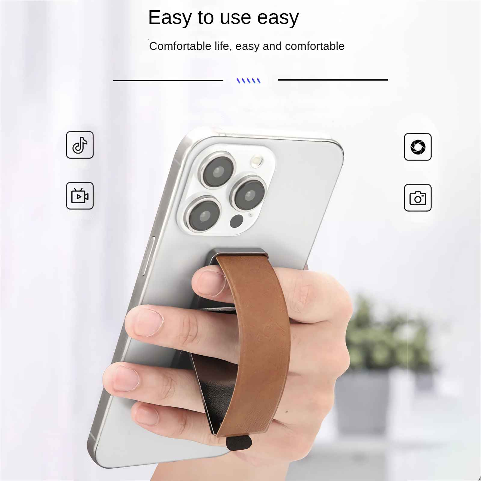 Eine Hand hält ein silbernes Smartphone mit einem braunen Ledergriff.