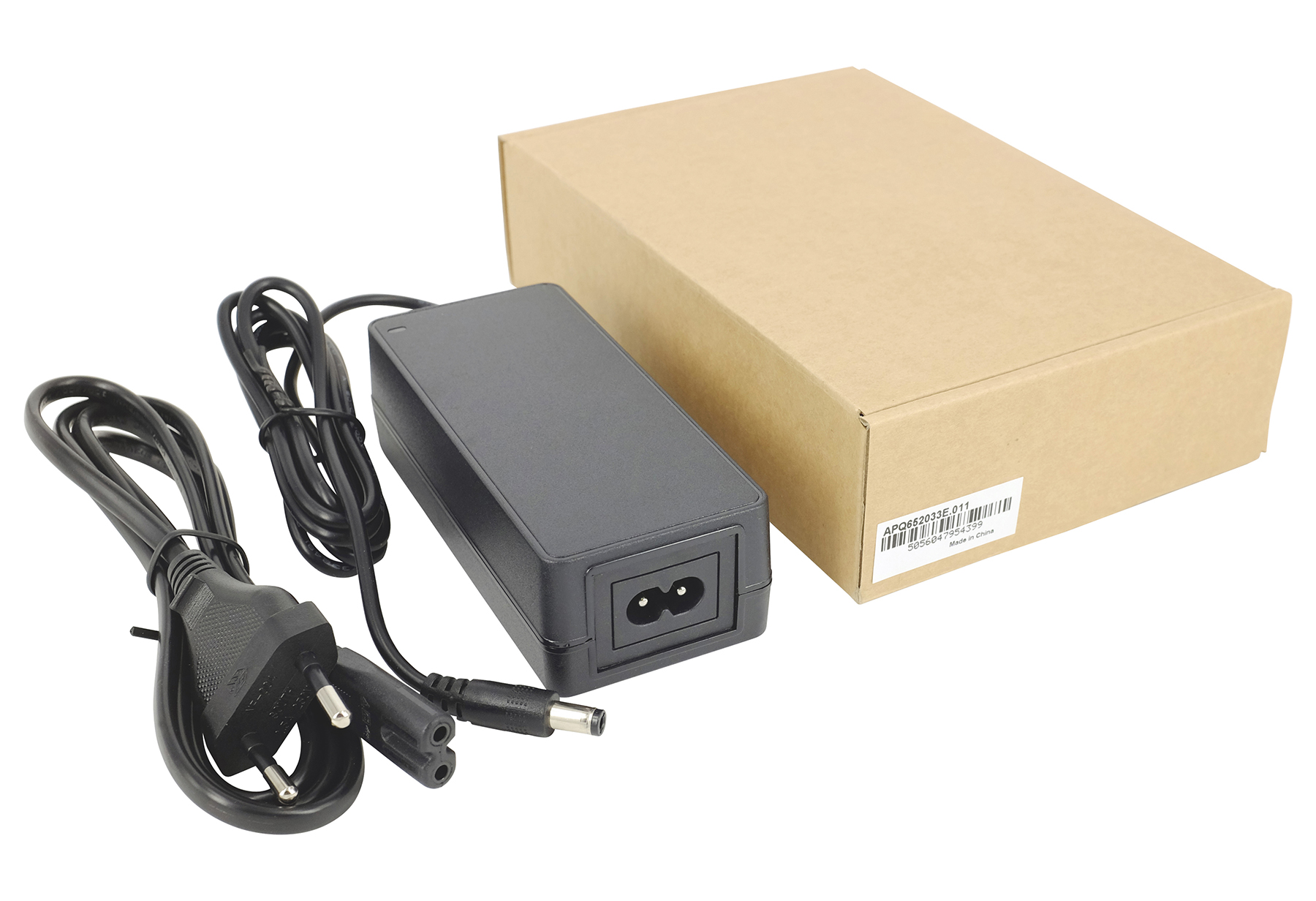 Schwarzer Netzadapter mit Kabeln und brauner Kartonverpackung auf weißem Hintergrund.