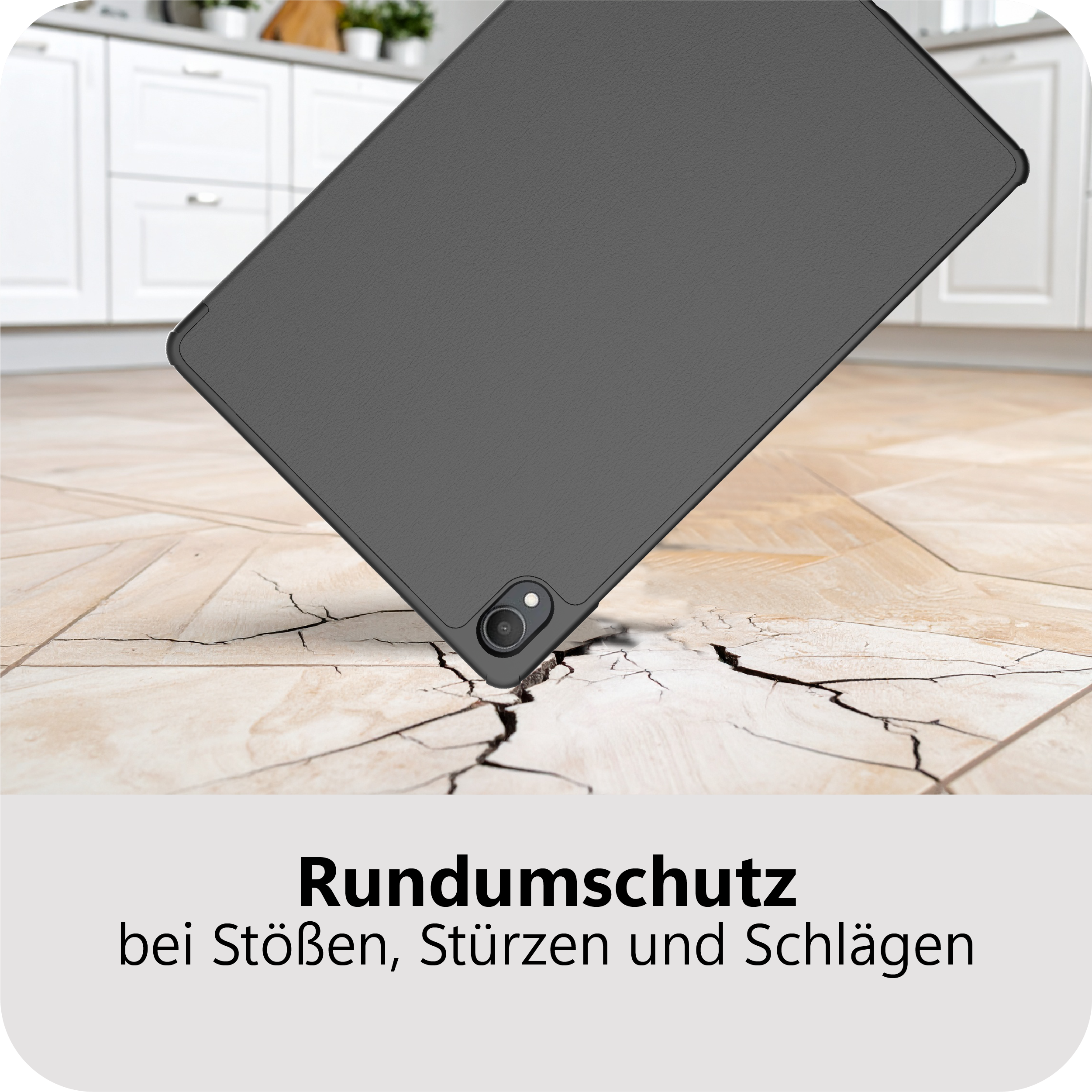 Graues Tablet fällt auf rissigen Boden vor Küchenschränken.