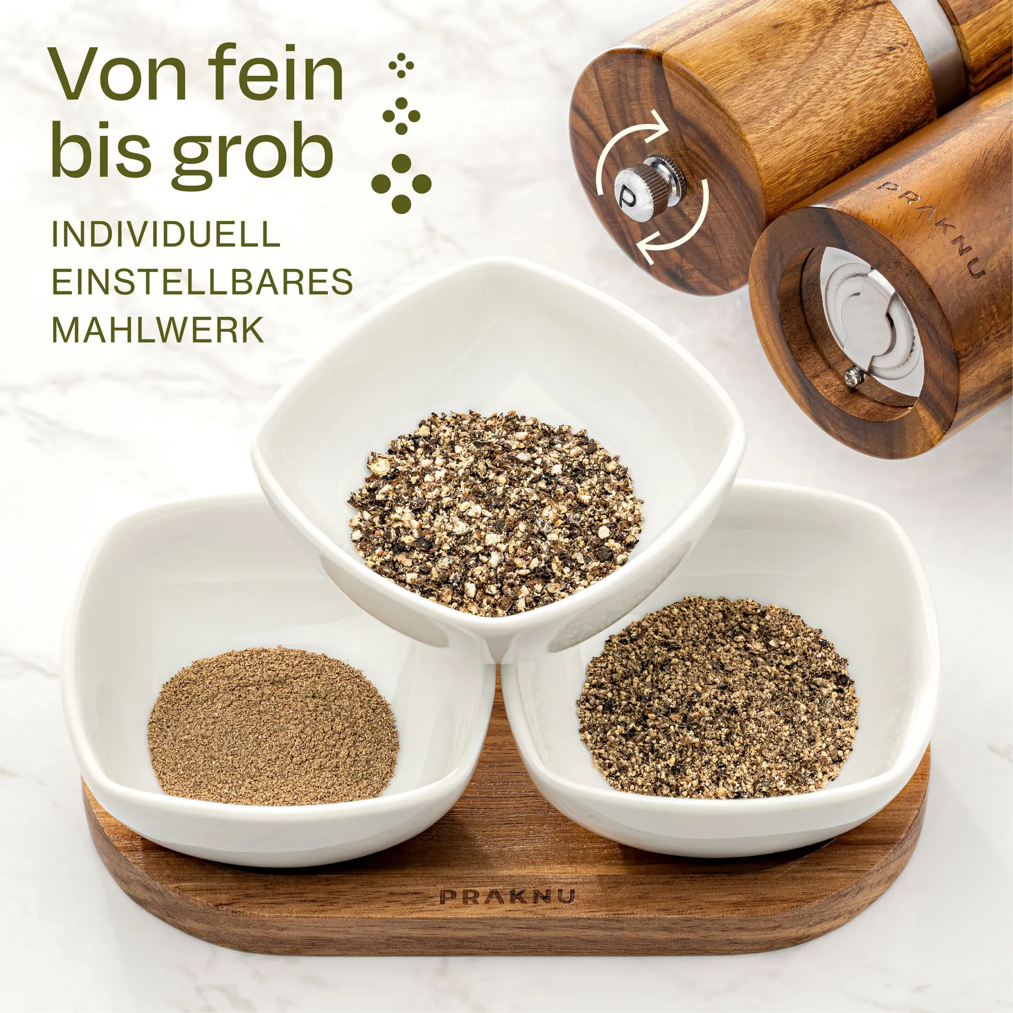 Drei Schalen mit Pfeffer unterschiedlicher Körnung und Holz-Pfeffermühlen.