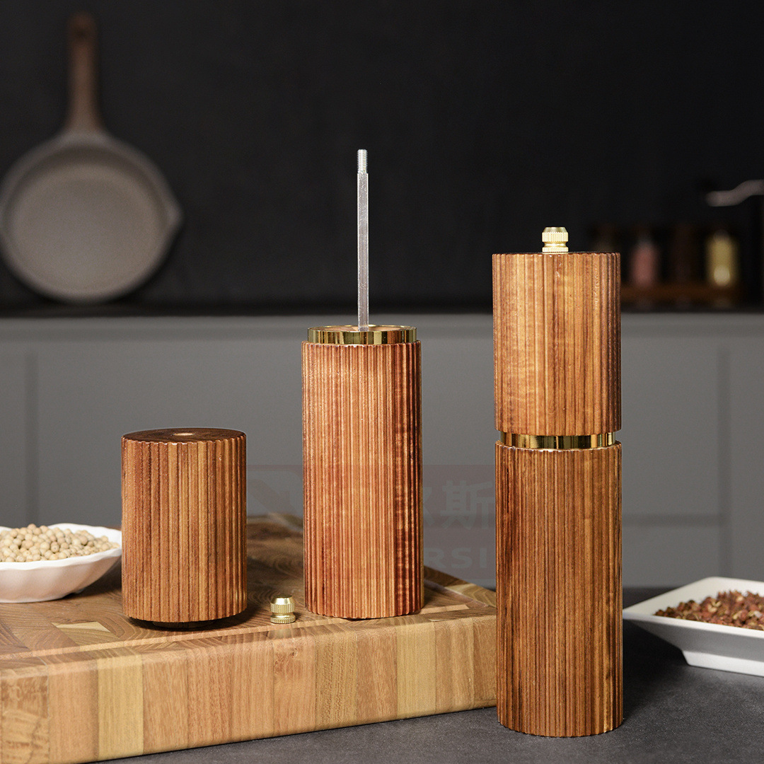 Holzmühlen für Gewürze mit goldenen Akzenten stehen auf einem Holzbrett.