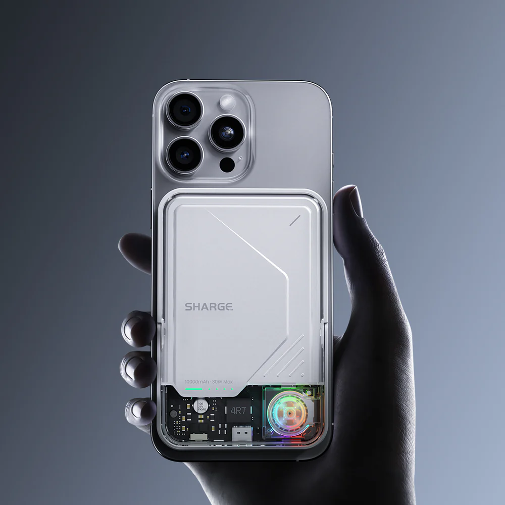 Une main tient un téléphone transparent avec un étui de chargement blanc montrant un composant de ventilateur coloré.