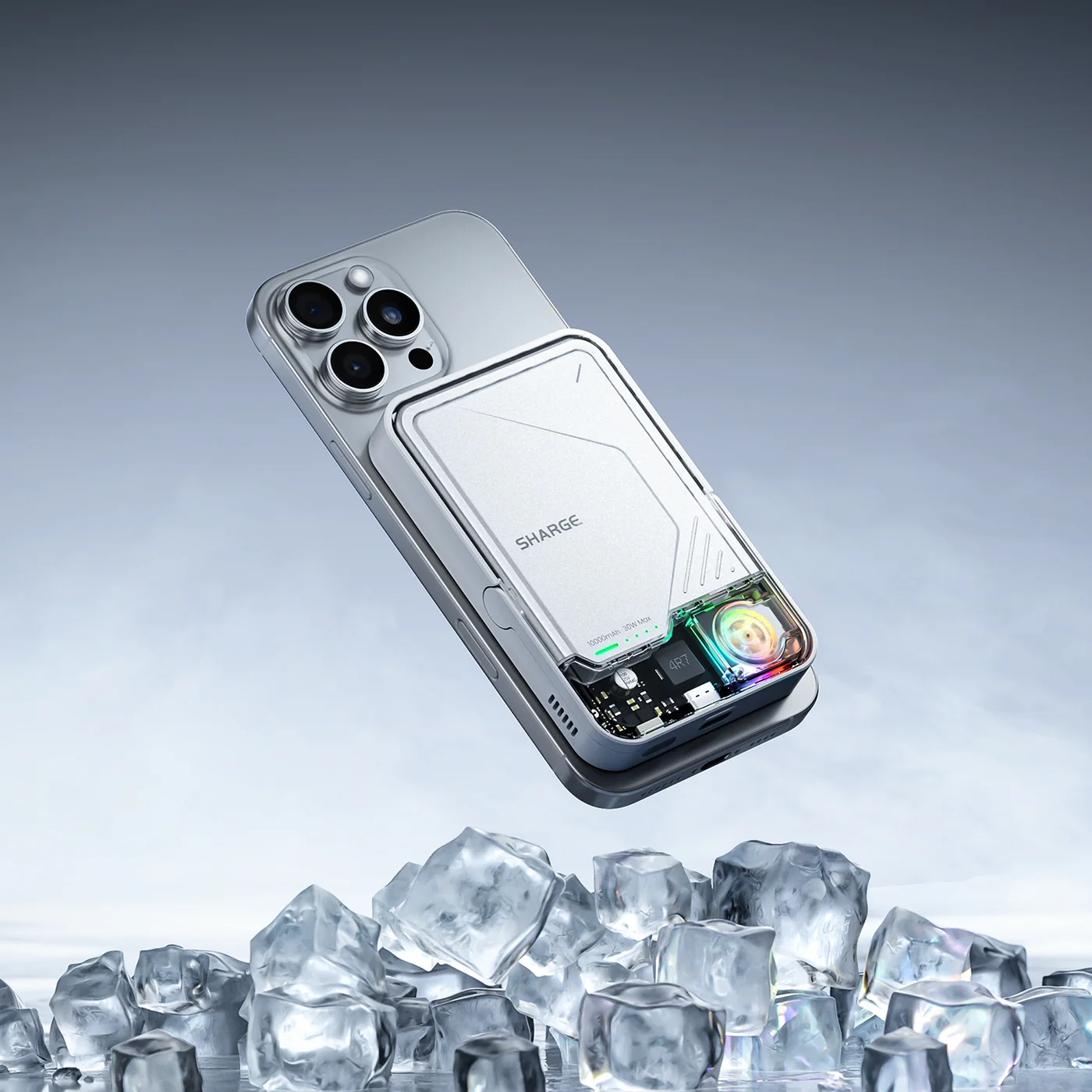 Un smartphone argenté avec batterie blanche attachée flotte au-dessus de glaçons.