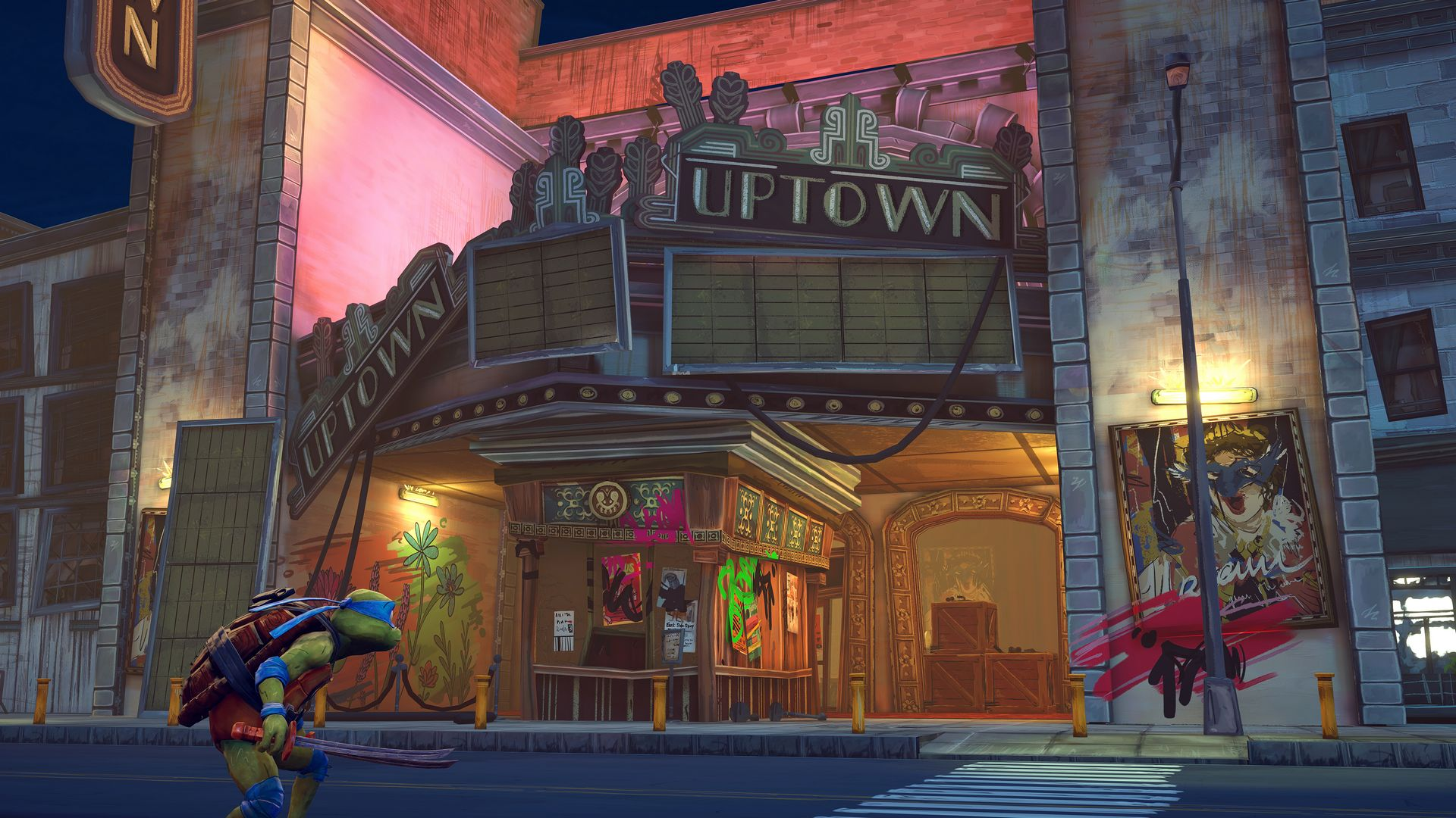 Żółw Ninja stoi przed teatrem "Uptown" w wieczornym świetle.