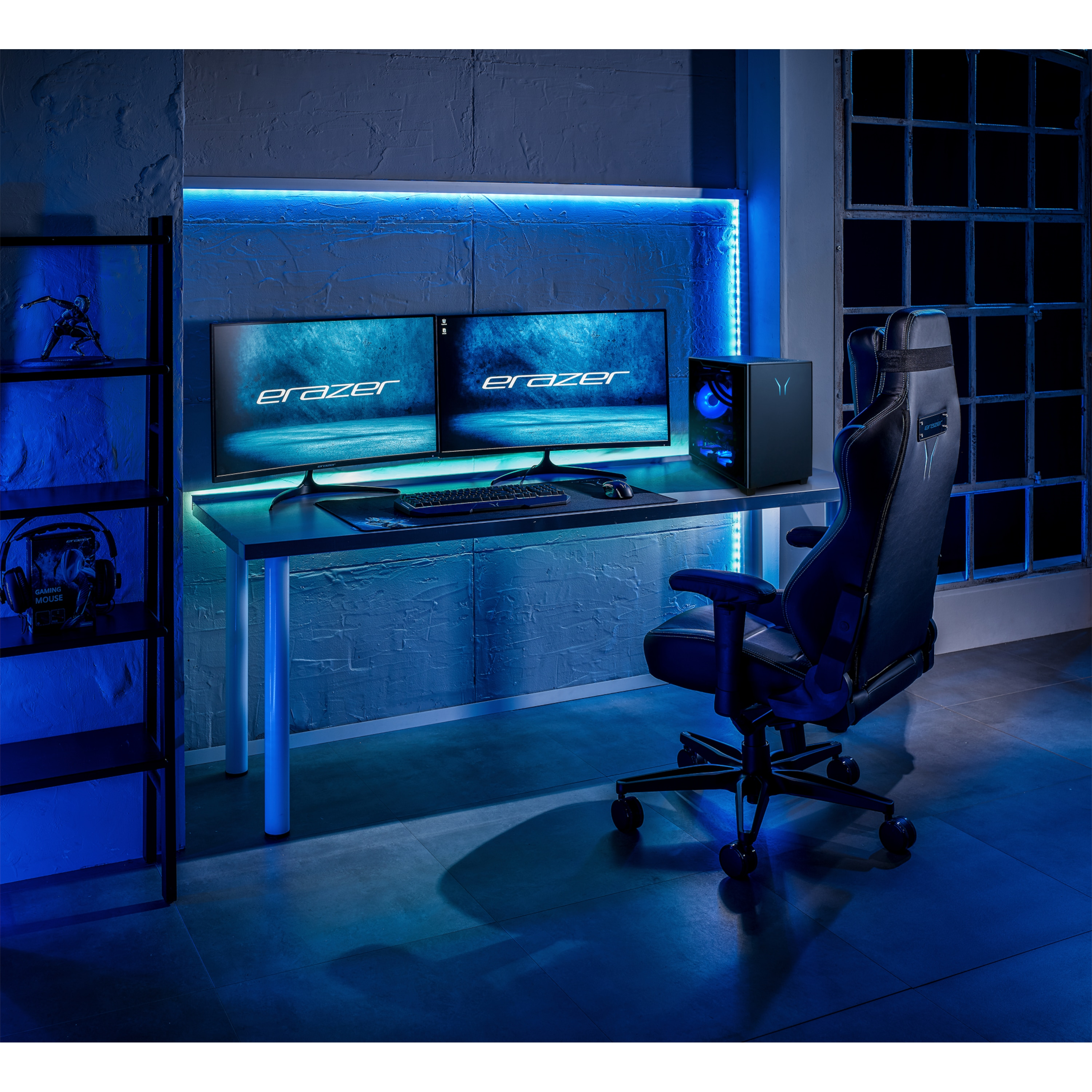 Una postazione da gioco con due monitor, PC, tastiera, mouse e sedia in luce blu.