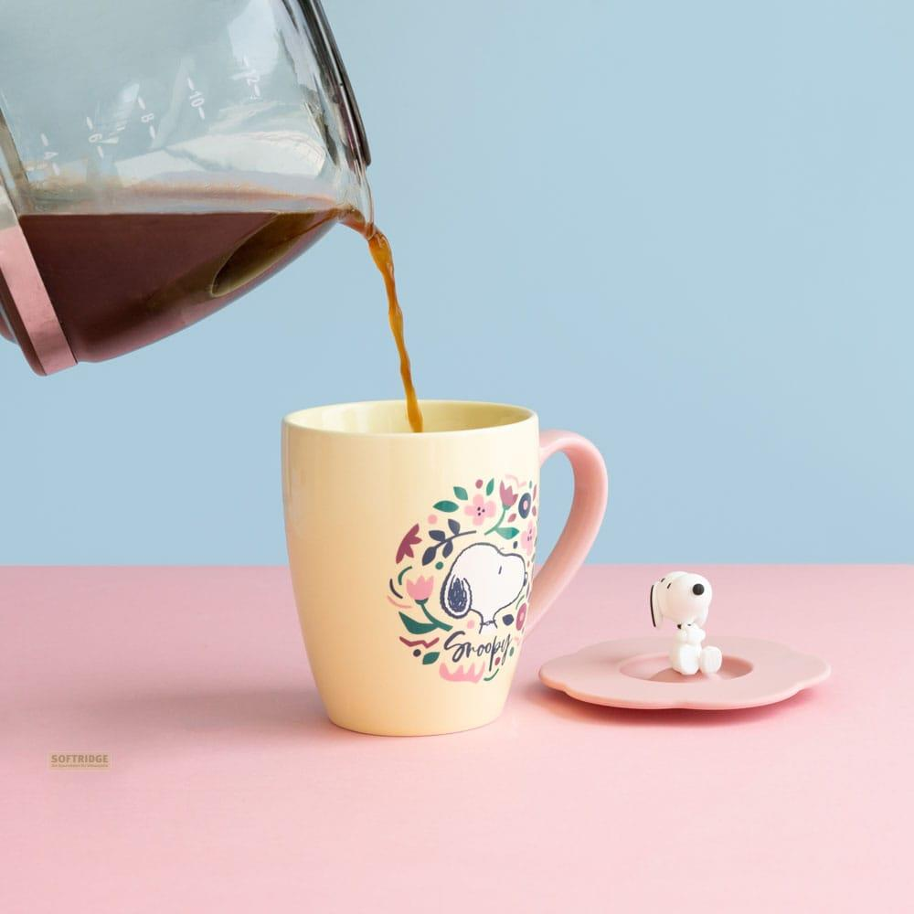 Kaffee wird in eine gelbe Tasse mit Snoopy-Aufdruck gegossen.