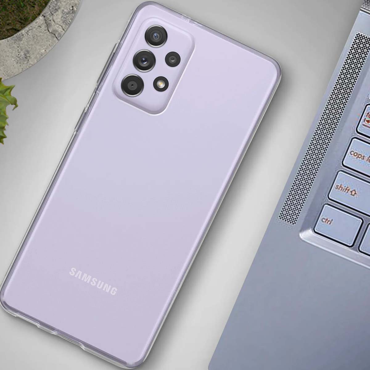 Uno smartphone Samsung viola giace accanto a un laptop.