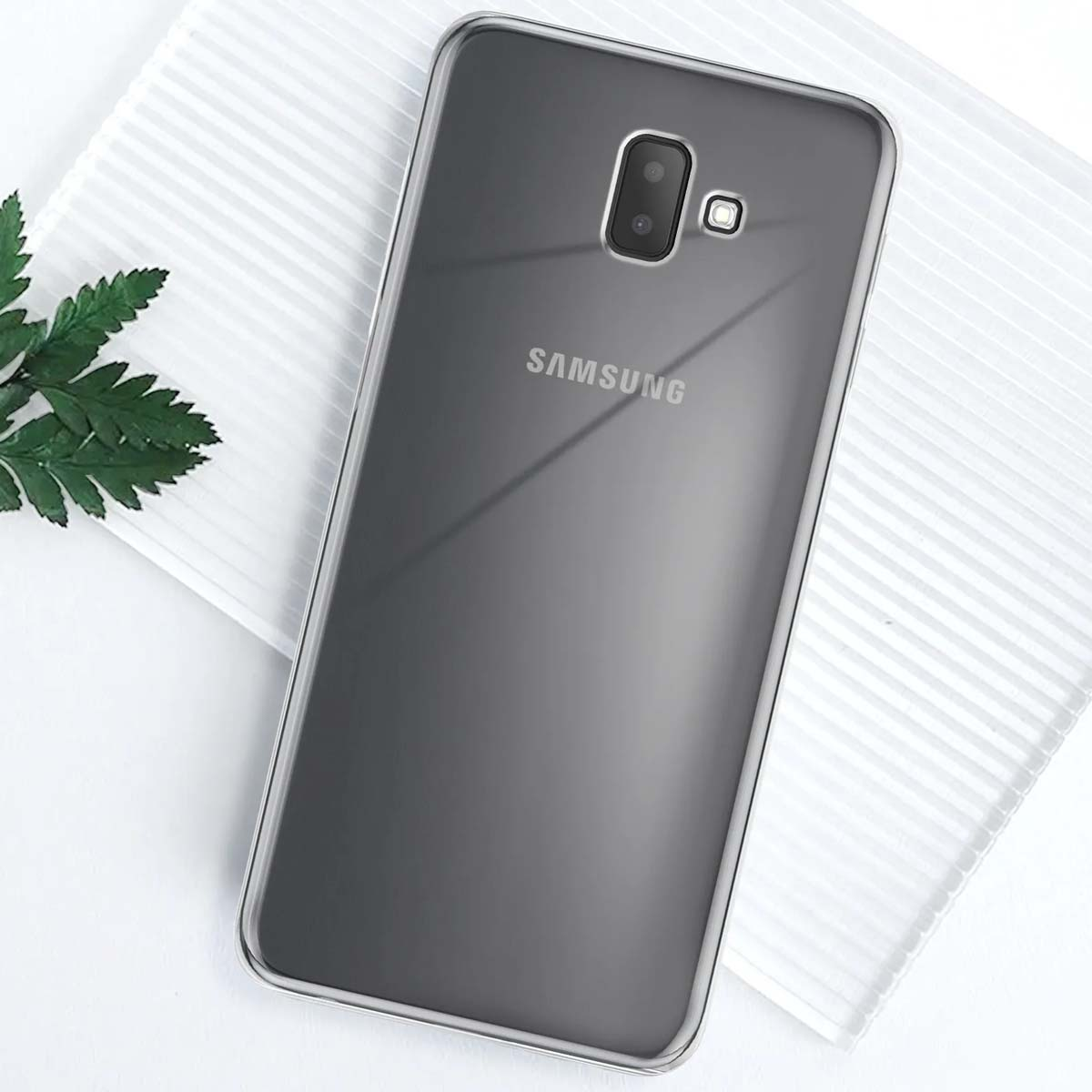 Telefono Samsung grigio scuro con doppia fotocamera su superficie bianca.