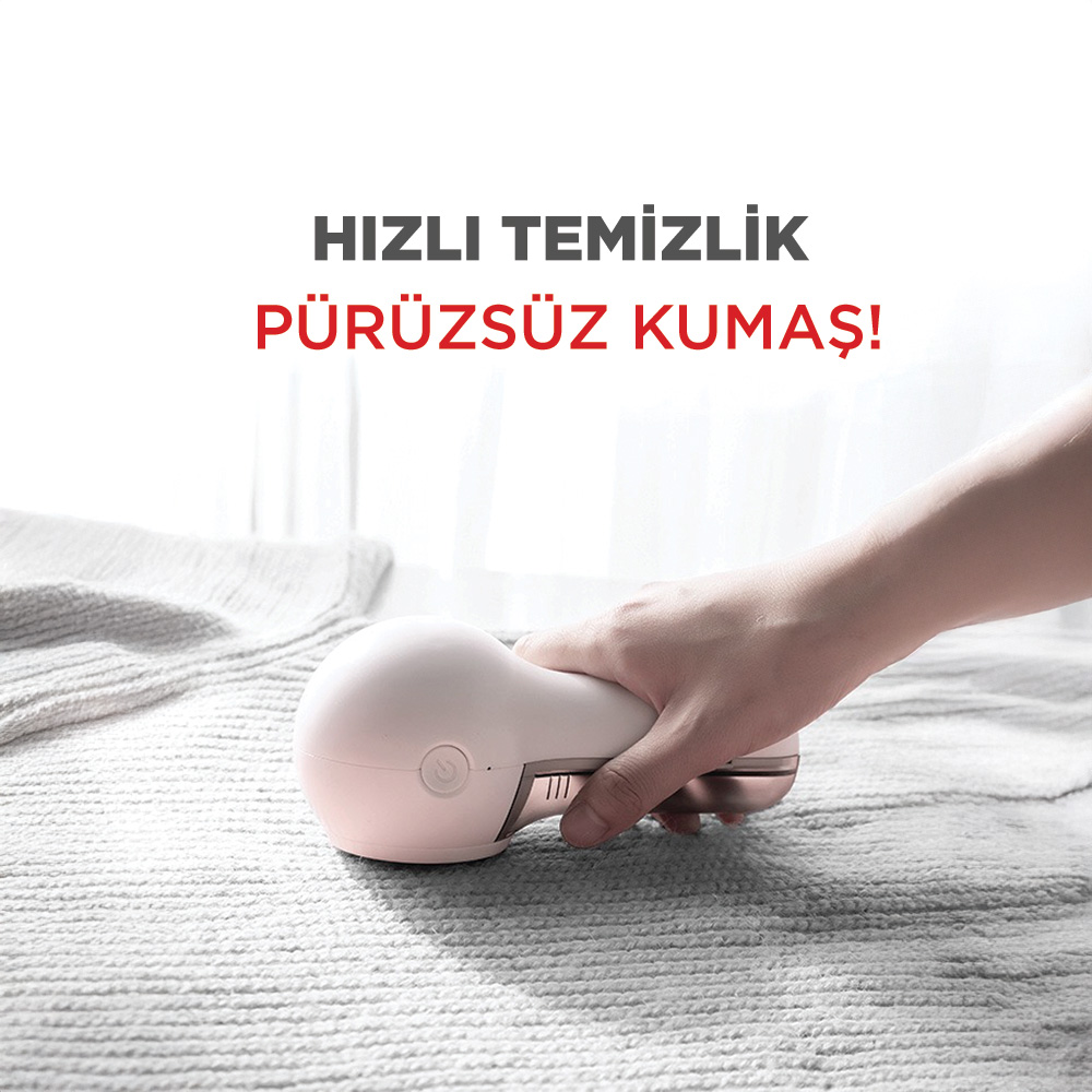 Gri halı üzerinde beyaz kumaş tüy giderici tutan bir el.