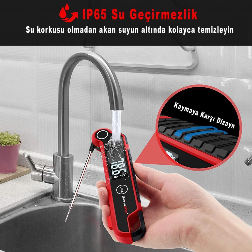Kırmızı bir termometre lavaboda akan su altında temizleniyor.