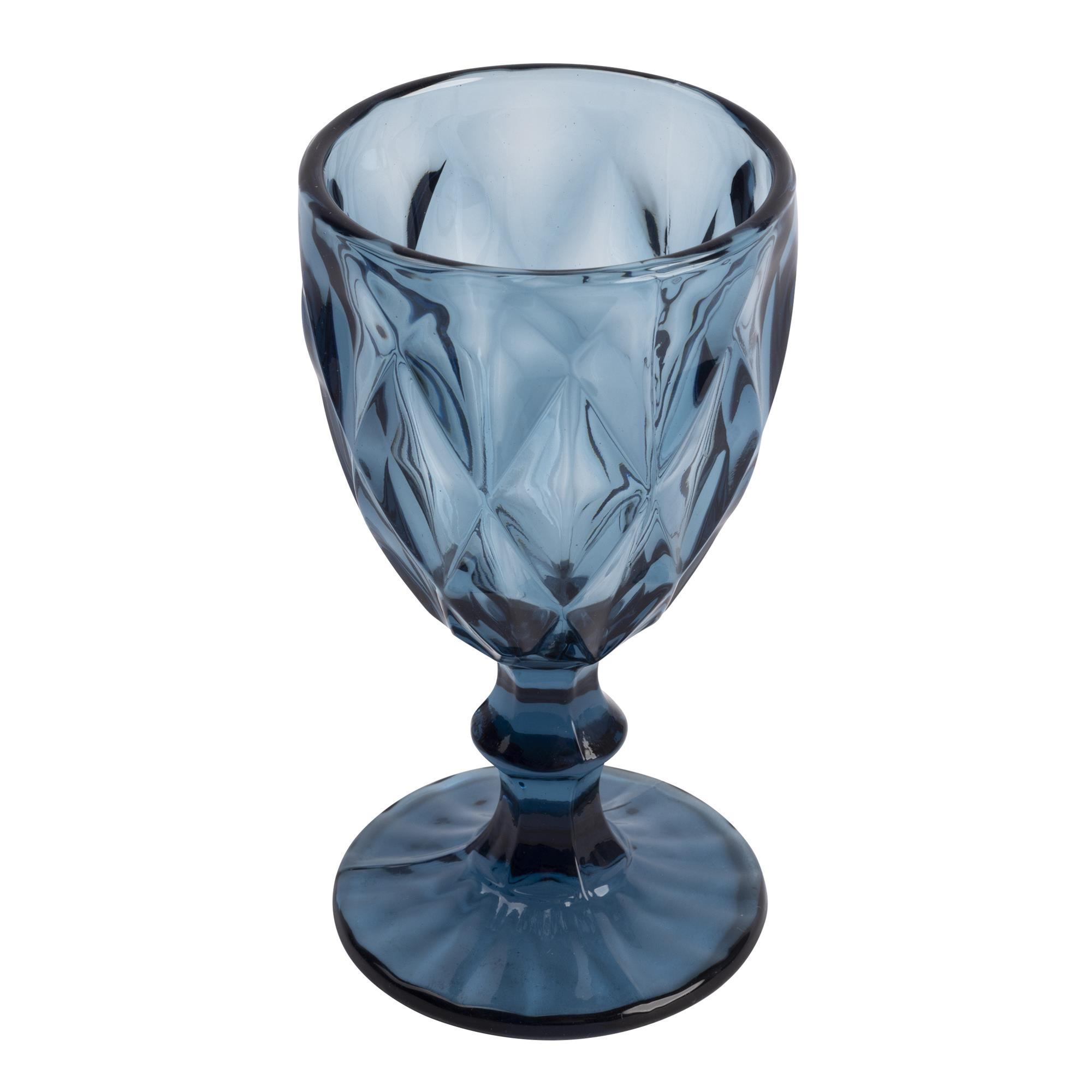 Una copa de cristal azul con diseño facetado se apoya en una base redonda.