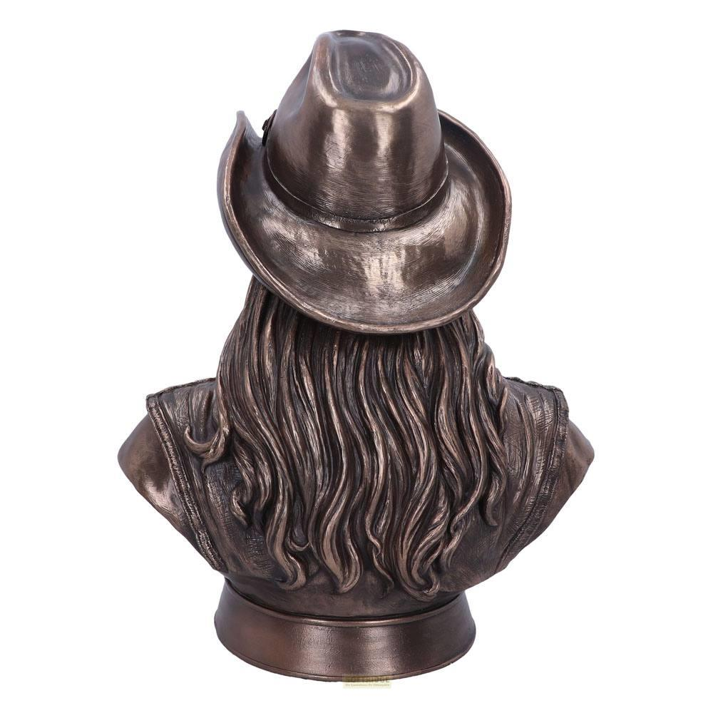 Bronzefigur von hinten: Frau mit Cowboyhut und langen Haaren, trägt Weste.