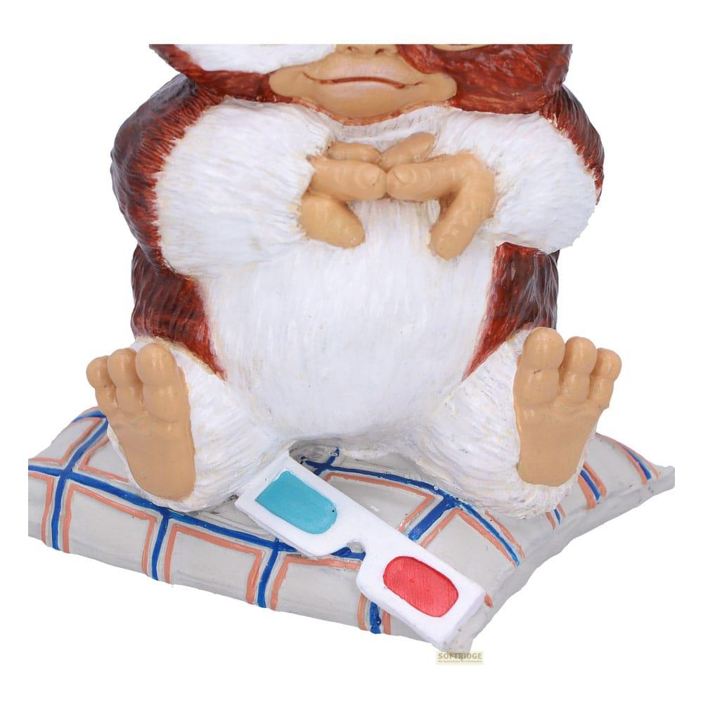 Eine Affenfigur sitzt auf einem Kissen mit 3D-Brille.
