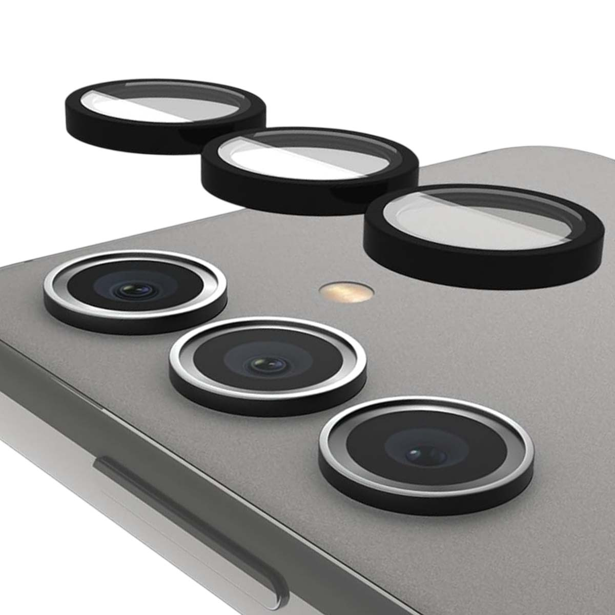 Tres protectores de lente negros con lentes de cristal sobre una superficie gris.