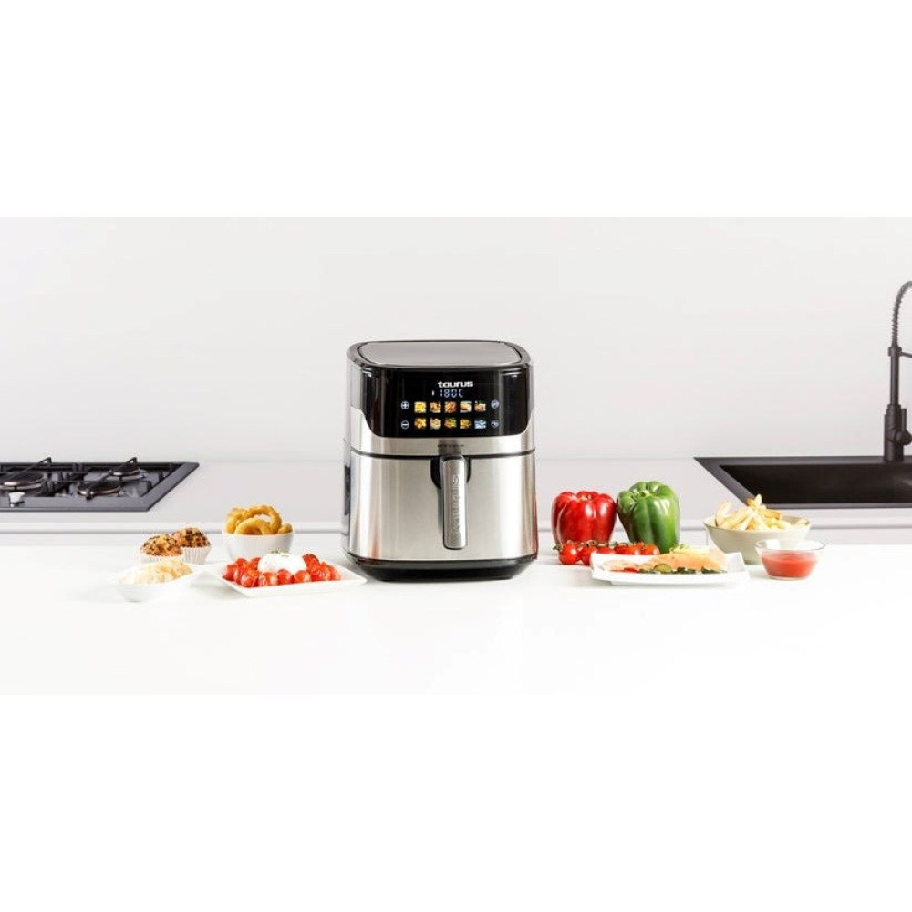 Srebrna frytkownica beztłuszczowa na blacie kuchennym z jedzeniem.