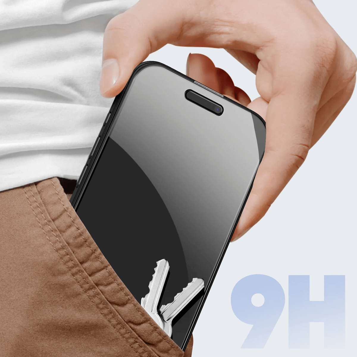 Una mano tiene uno smartphone che viene messo in una tasca. Si vedono due chiavi.