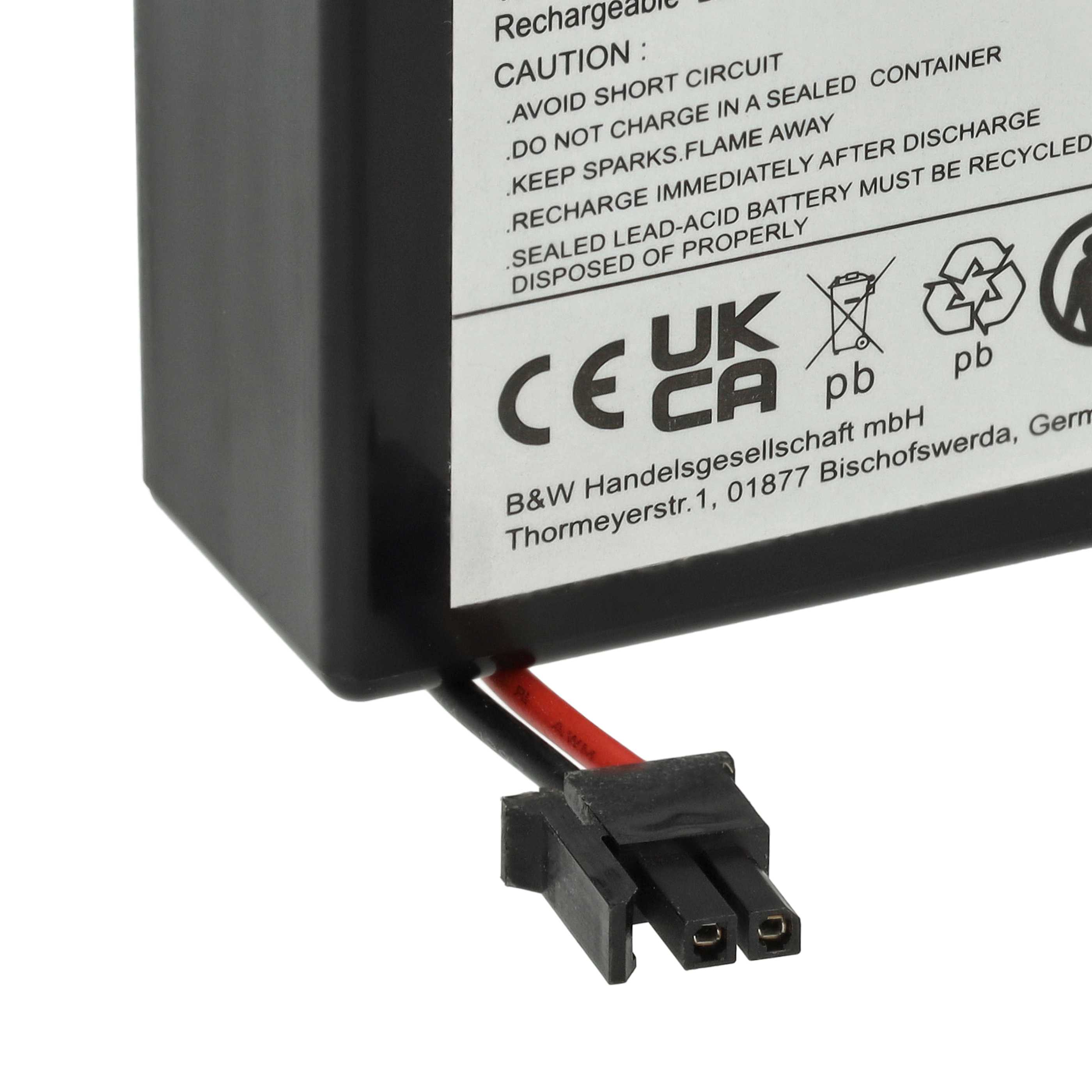 Schwarzer Stecker mit Kabeln und Warnhinweisen auf einer Batterie.