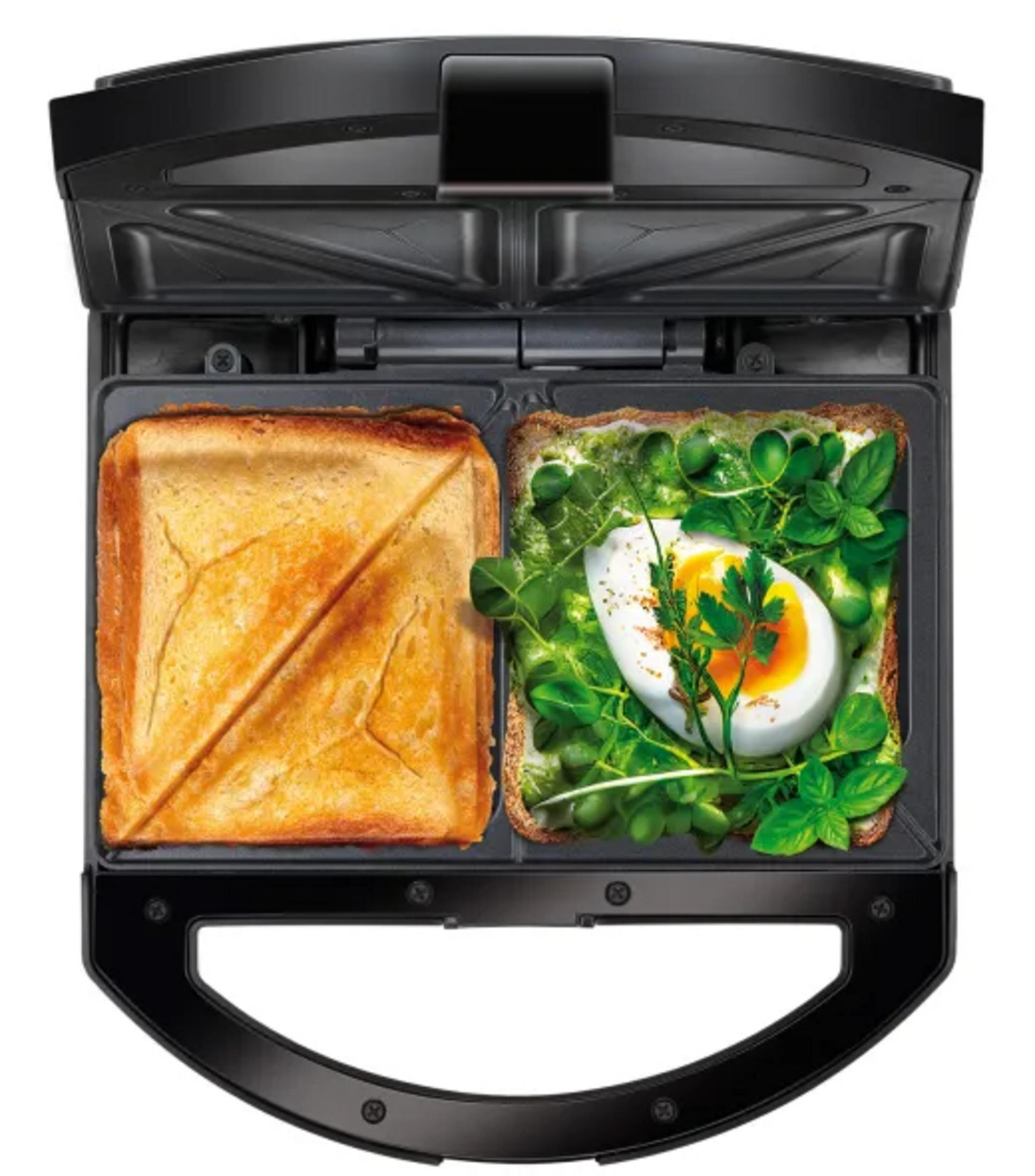 Un sandwich maker aperto con un toast e un sandwich con uovo ed erbe.