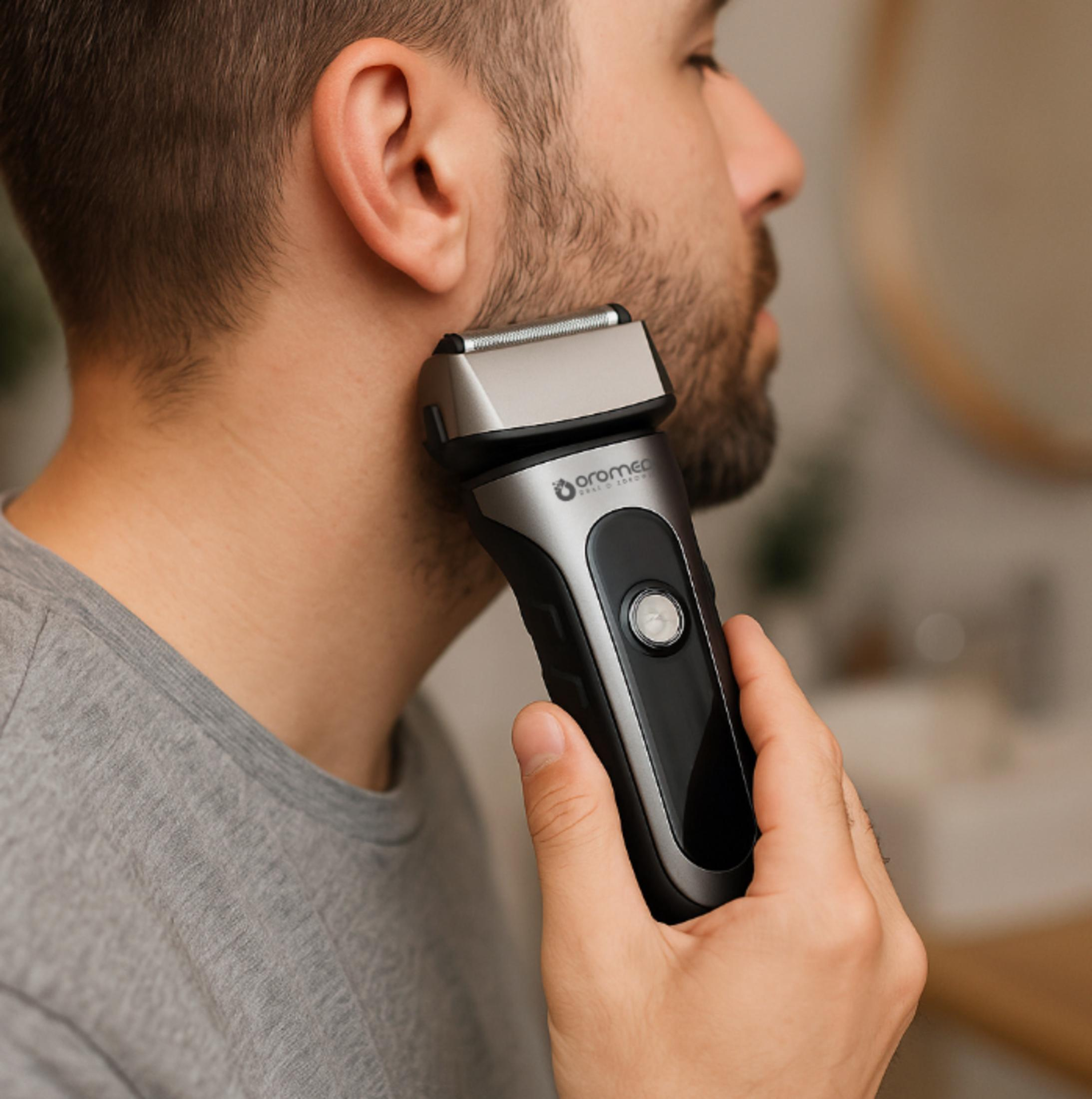 Uomo che si rade il viso con un rasoio elettrico nero e argento.