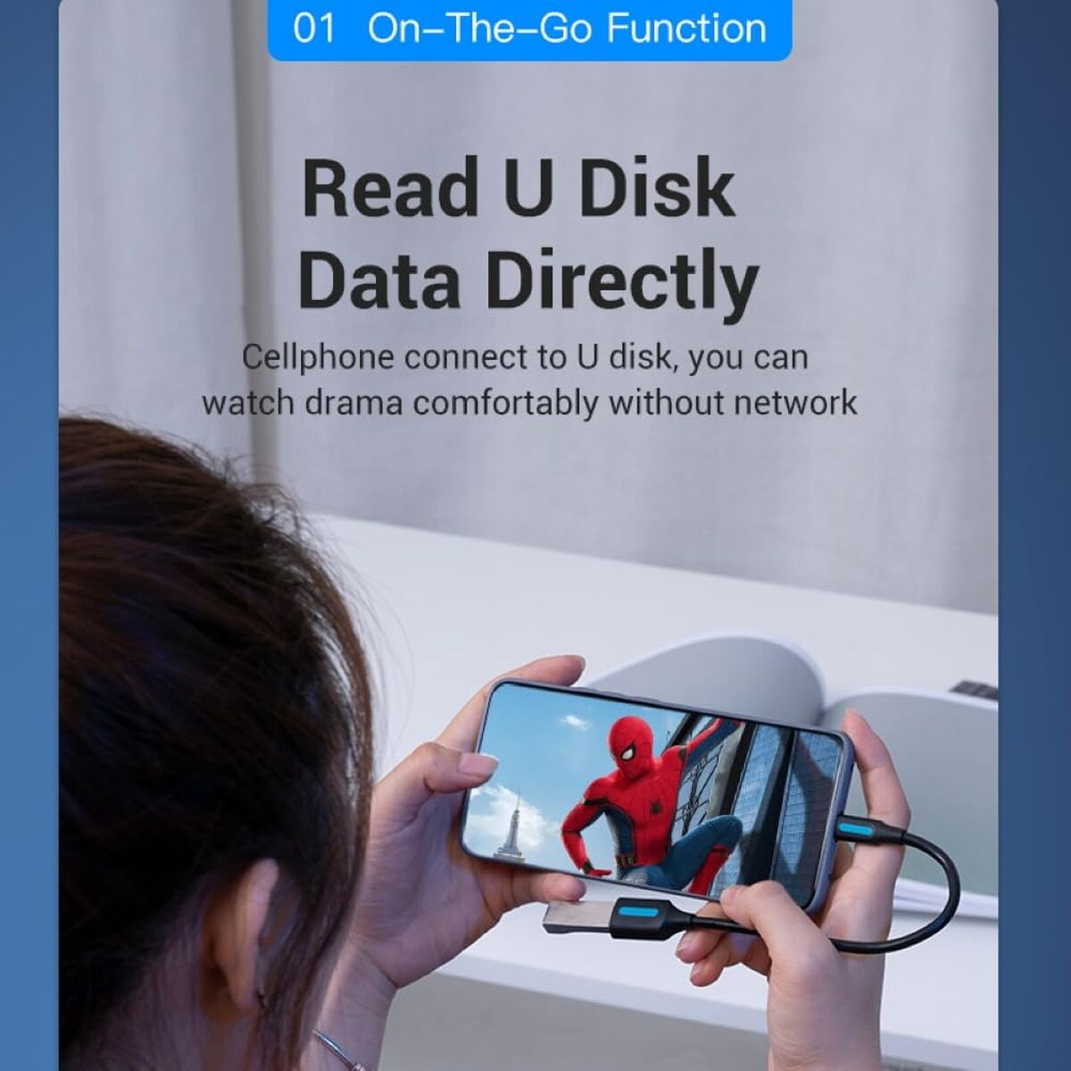 Una mano tiene un telefono con Spiderman, collegato da un cavo.