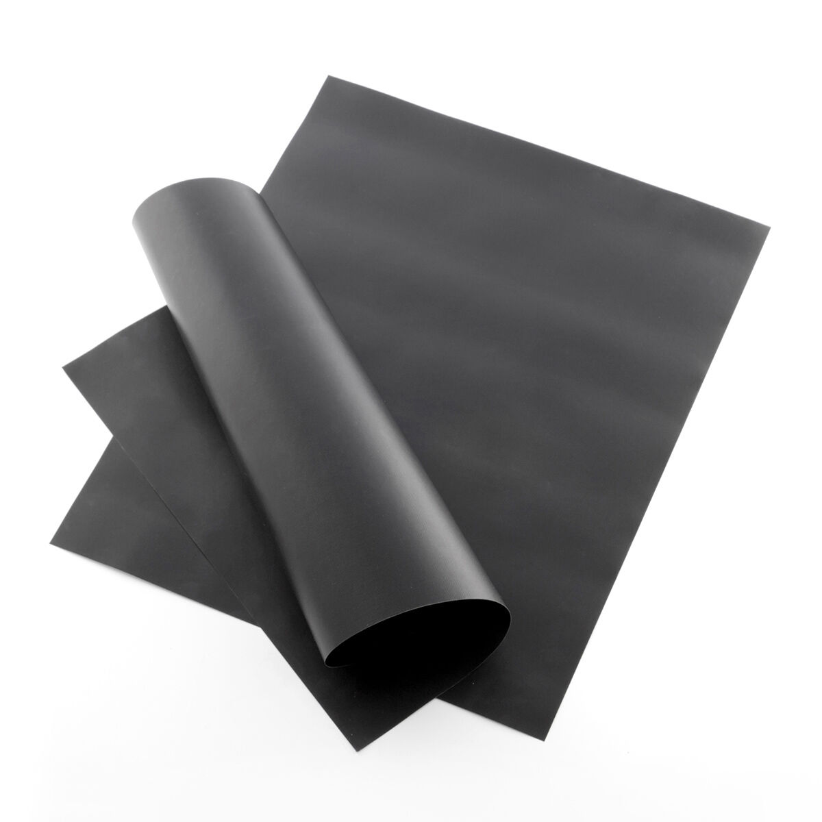 Papel negro, una hoja enrollada, otras planas, sobre fondo blanco.