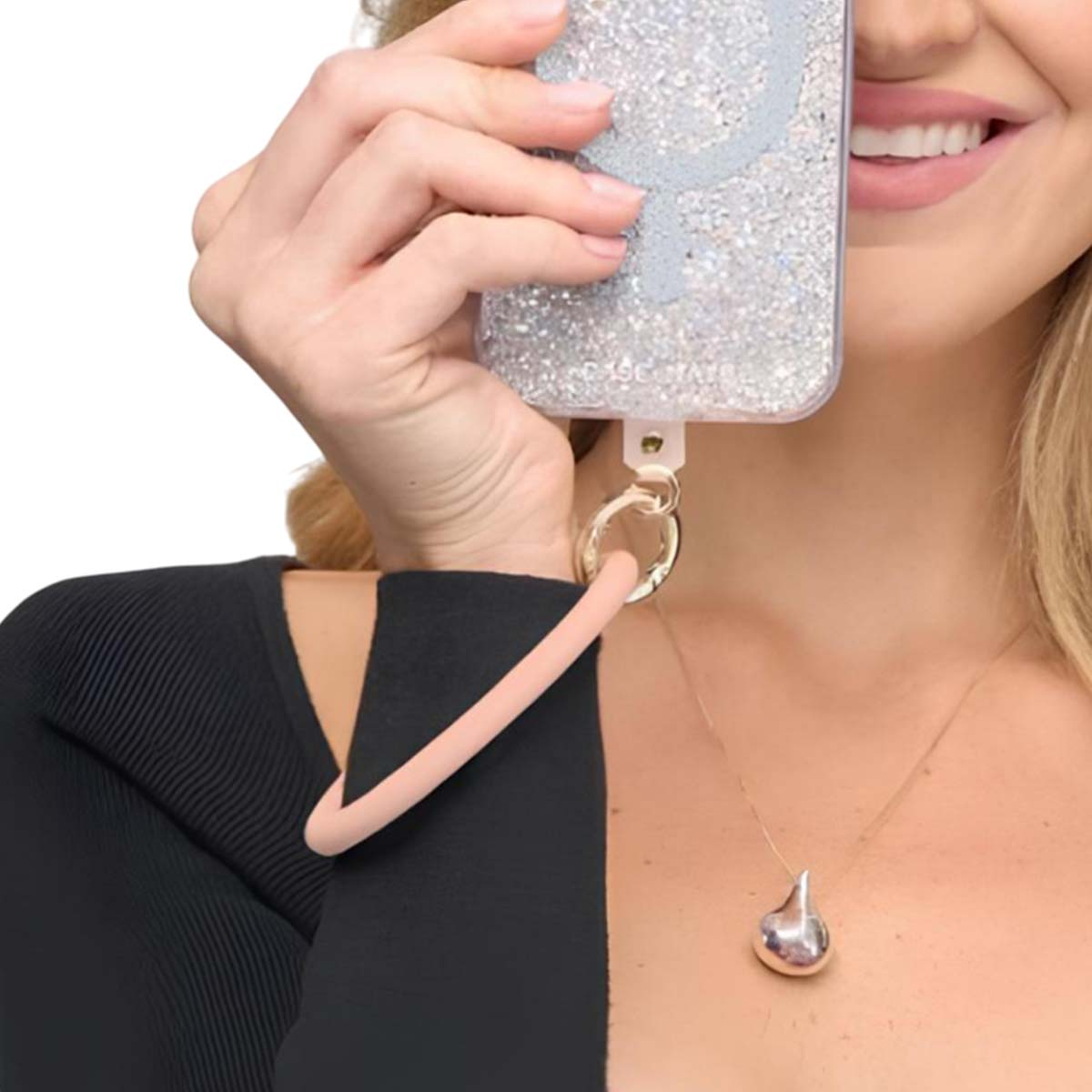 Eine Frau mit glitzernder Hülle hält ihr Handy, ein rosa Band ist befestigt.