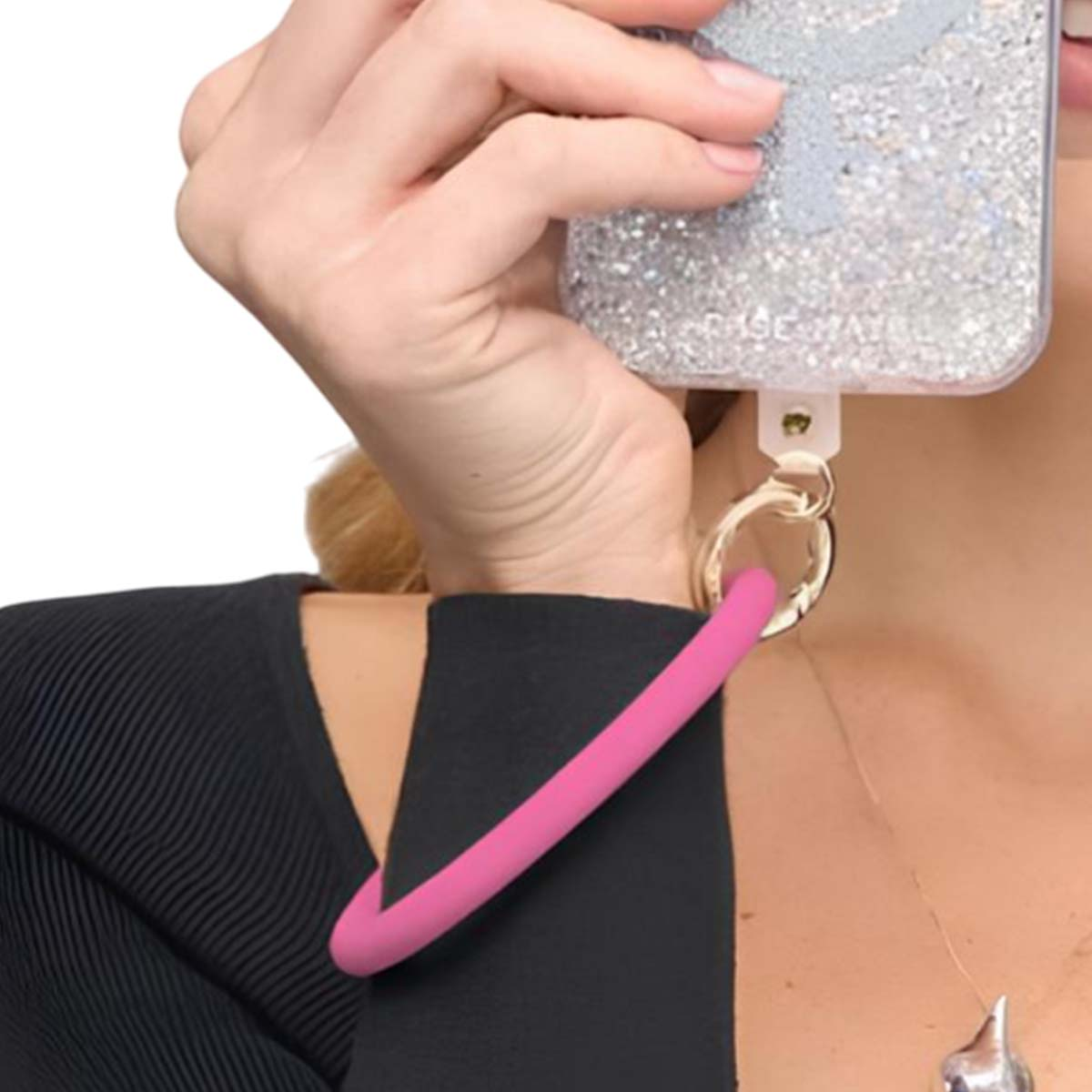 Eine Hand hält ein glitzerndes Handy mit einem pinken Riemen.