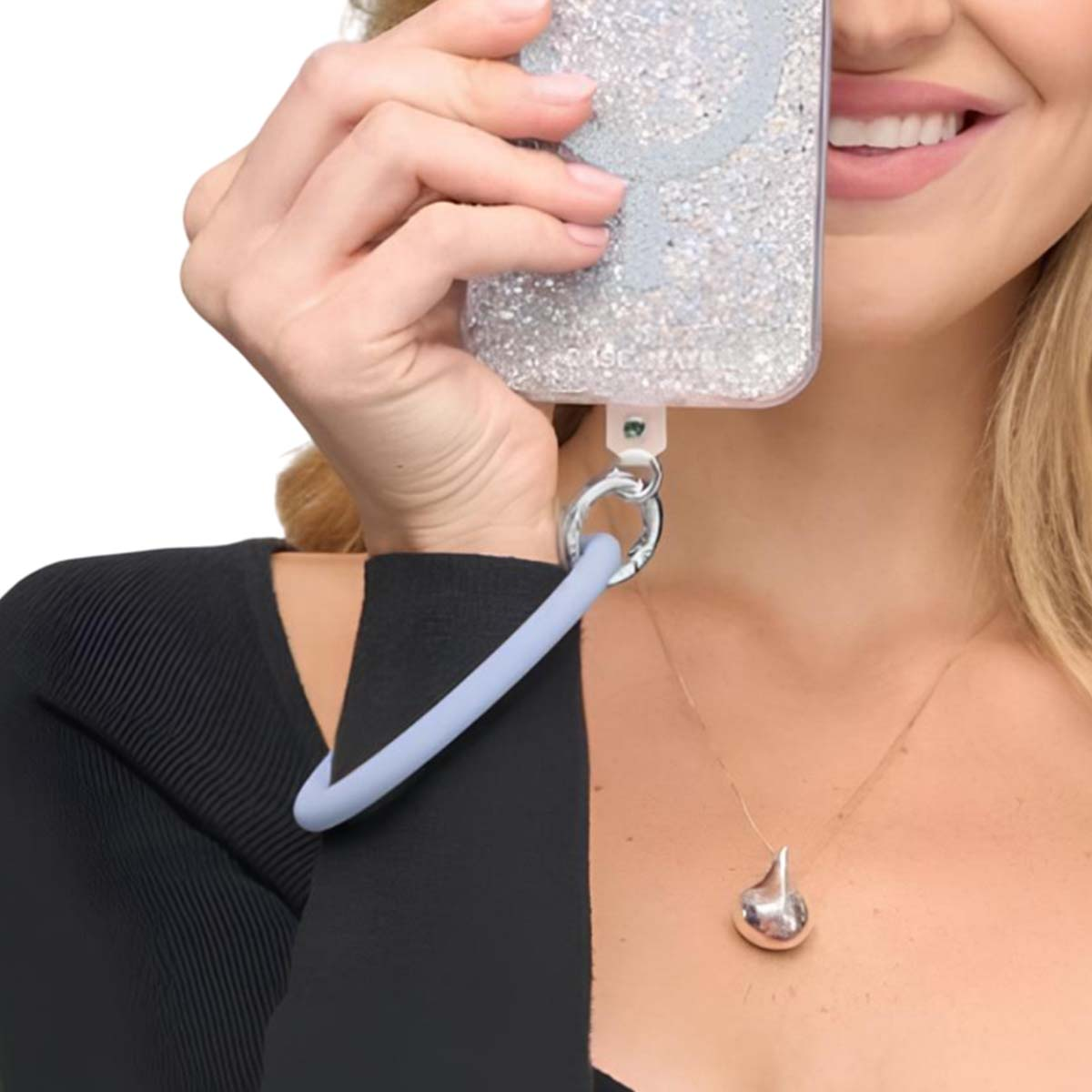 Una donna tiene un telefono scintillante con un cinturino azzurro.
