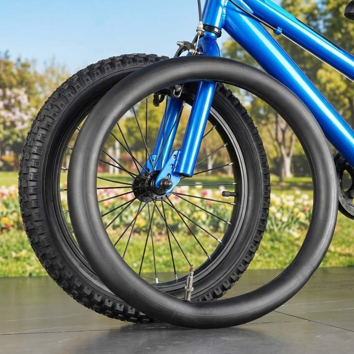 Ein blaues Fahrrad mit einem Reifen und einem Schlauch davor.