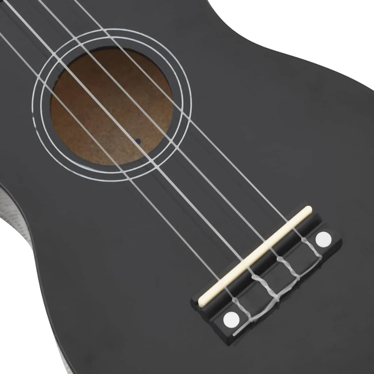Nahaufnahme des Korpus einer schwarzen Ukulele, mit Schallloch mit weißem Rand, vier weißen Saiten und dem Steg.
