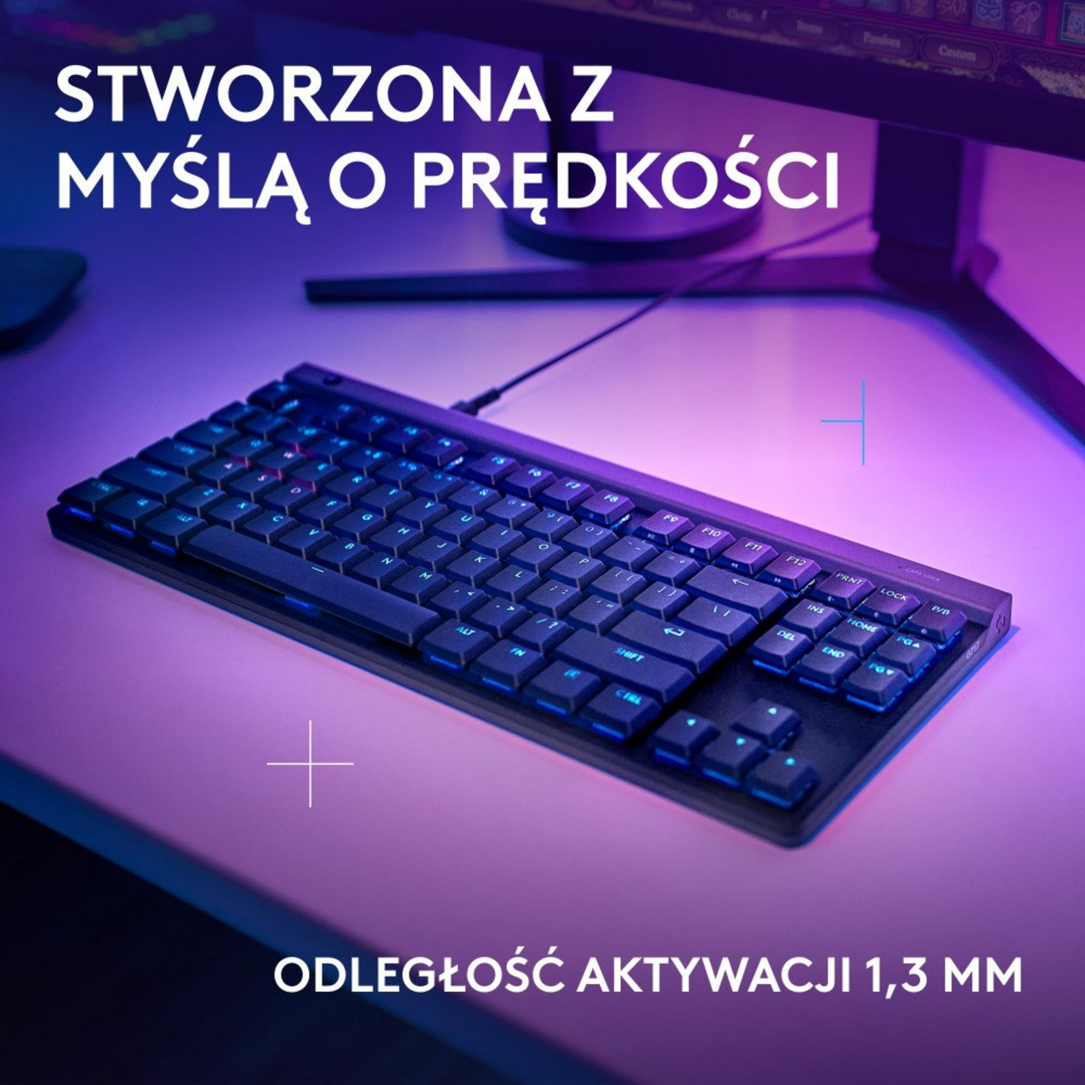 Un teclado negro con retroiluminación azul sobre un escritorio.