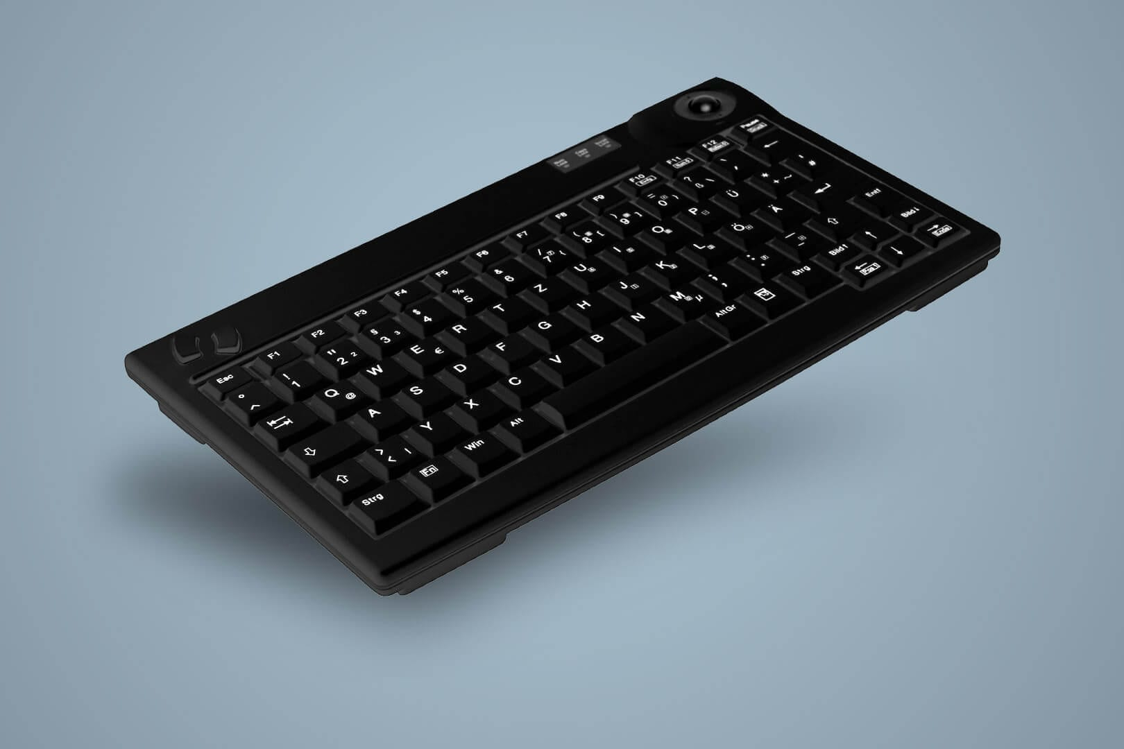 Teclado negro con trackball sobre fondo azul claro.