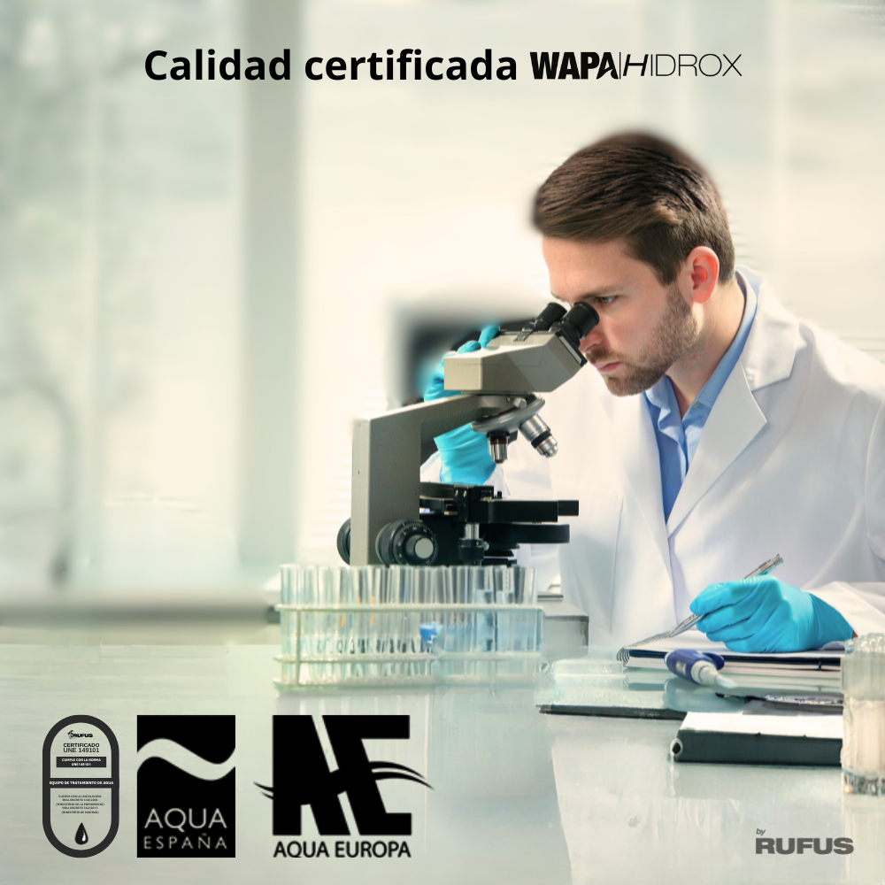 Hombre con bata de laboratorio mira por microscopio, tubos de ensayo y logos al frente.