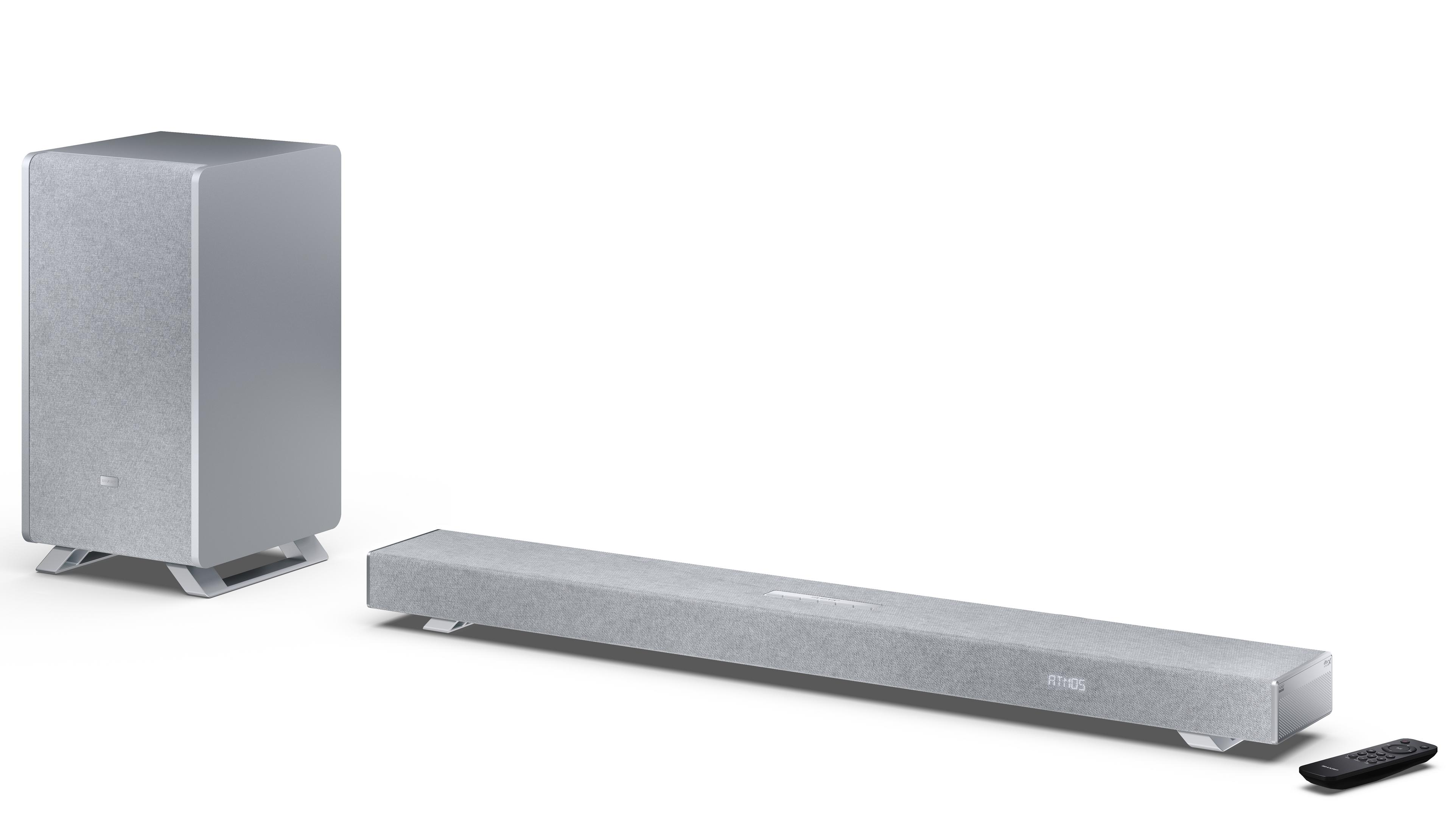 Silberne Soundbar und Subwoofer mit Fernbedienung auf weißem Hintergrund.