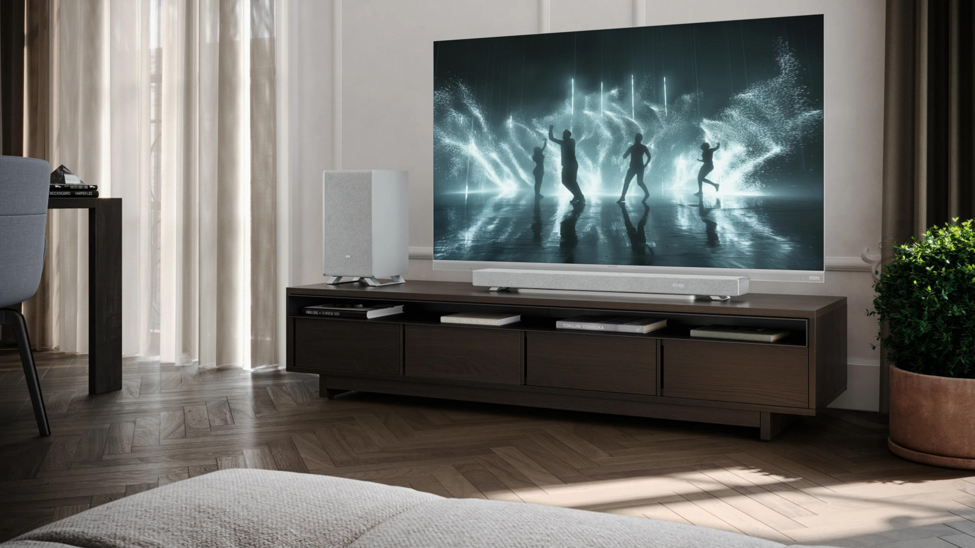 Ein Wohnzimmer mit Fernseher, Lautsprechern und Pflanzen.