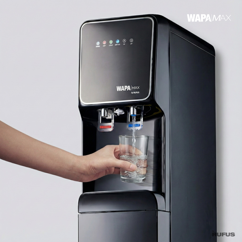 Una mano sostiene un vaso bajo un dispensador de agua negro mientras se llena.