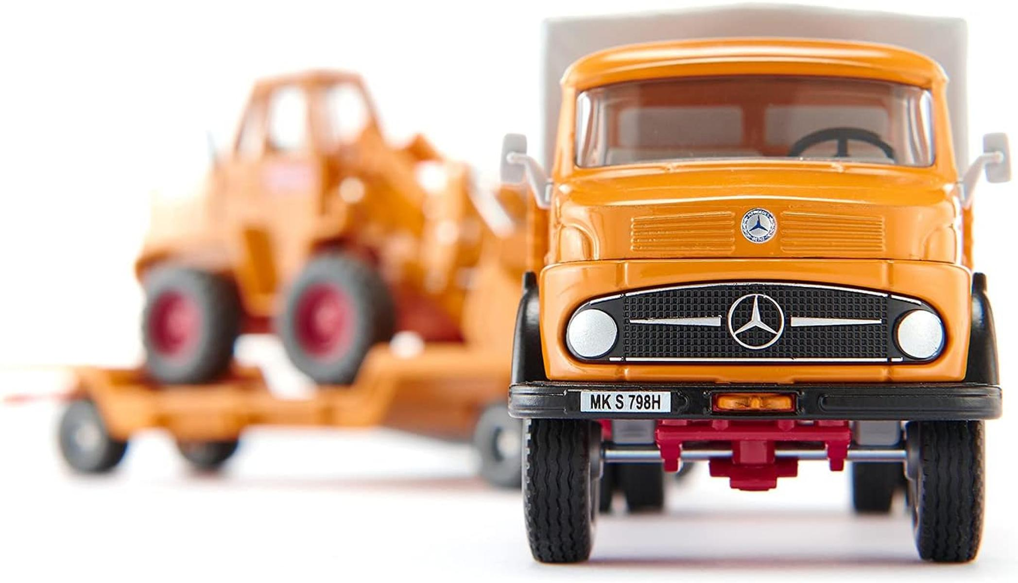 Eine orangefarbene Spielzeug-Sattelschlepper mit einem Anhänger im Hintergrund.