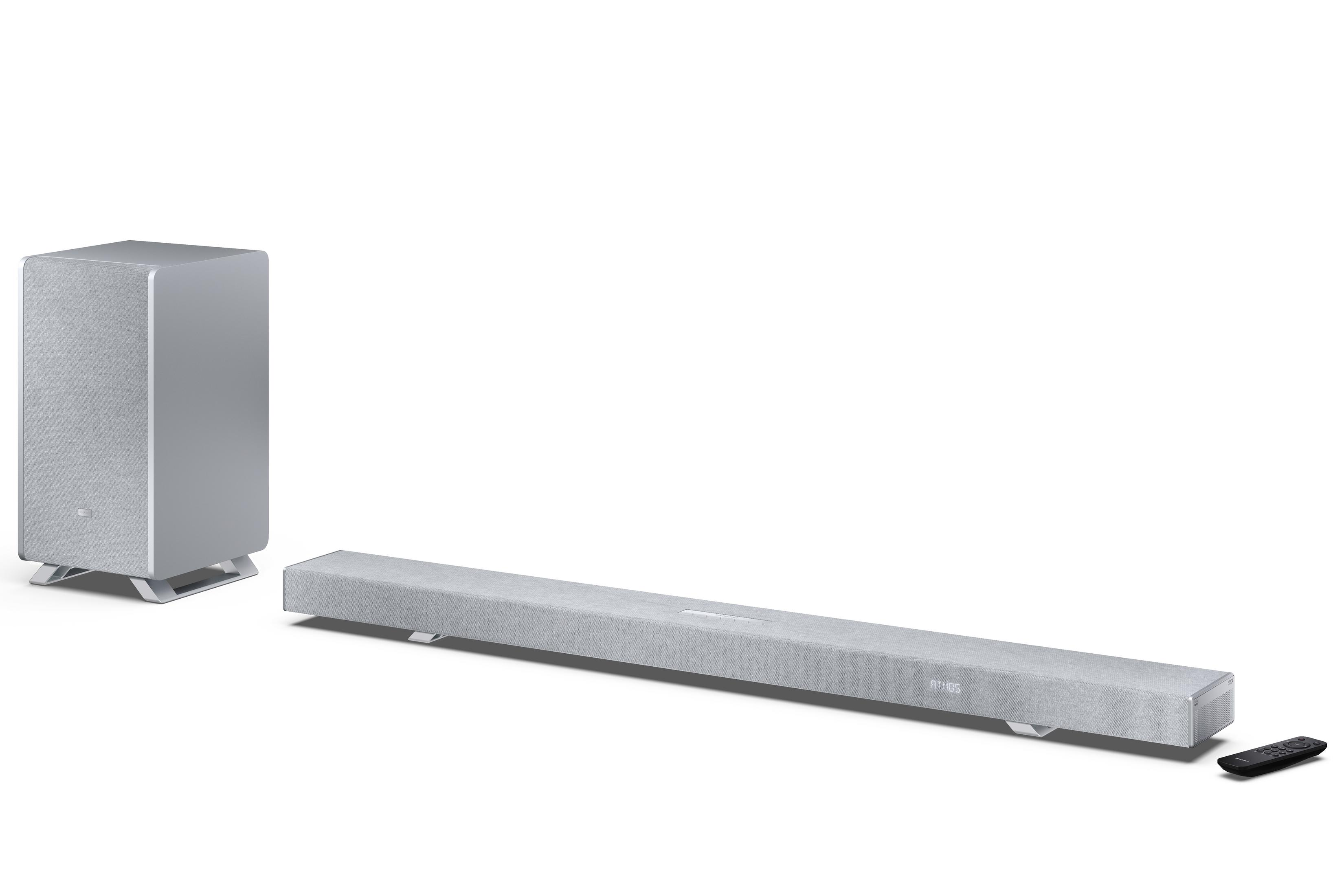 Grauer Subwoofer, Soundbar und Fernbedienung auf weißem Hintergrund.