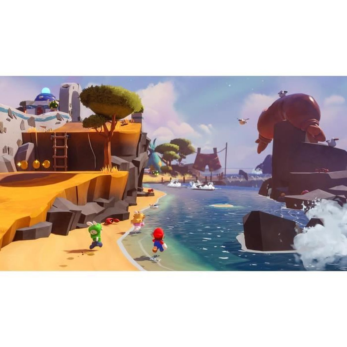 Mario i Rabbids eksplorują słoneczną plażę z wodą, skałami i budynkami.