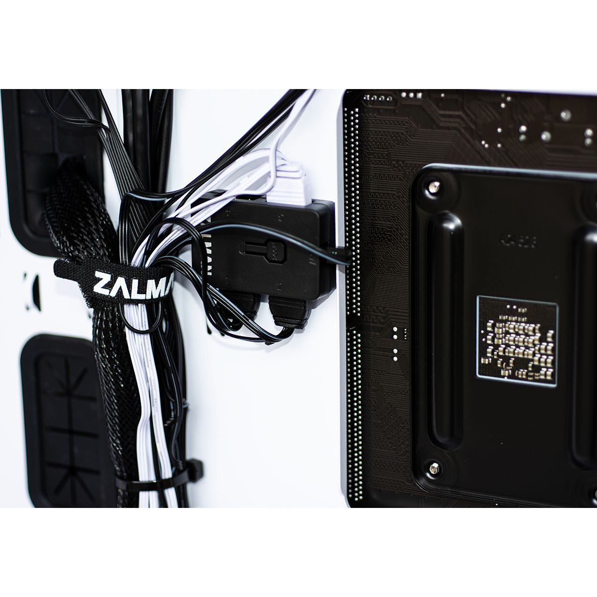 Zalman kabelbinder bundelt computerdraden verbonden met zwarte hub op achterkant moederbord.