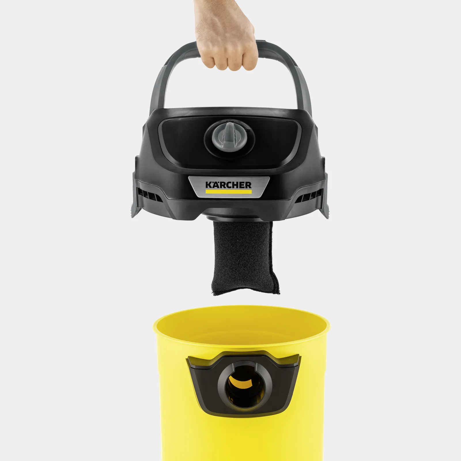 Hand holding black Karcher vacuum head over yellow container.