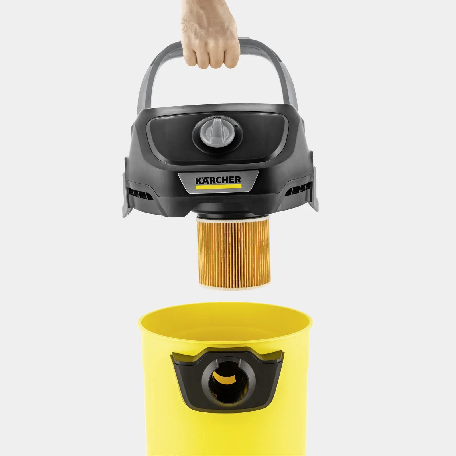 Hand holding Karcher vacuum head, filter being removed. Yellow container.