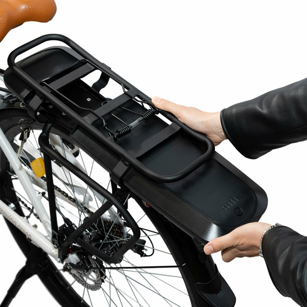 Persona attacca portapacchi nero a bicicletta bianca con sella marrone.