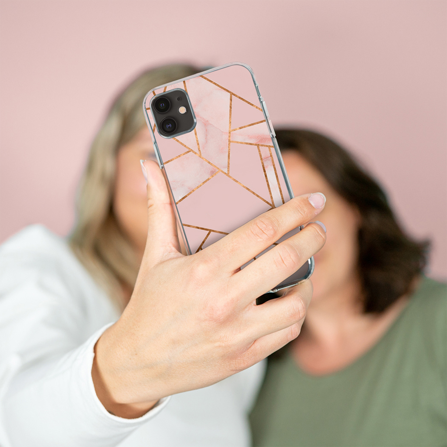 Due donne si scattano un selfie con un telefono con motivo marmorizzato.